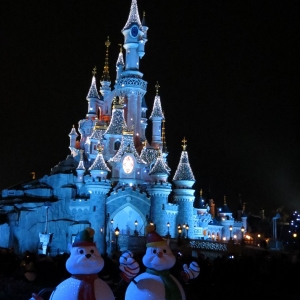 Snowmen in front of castle at night - portrait