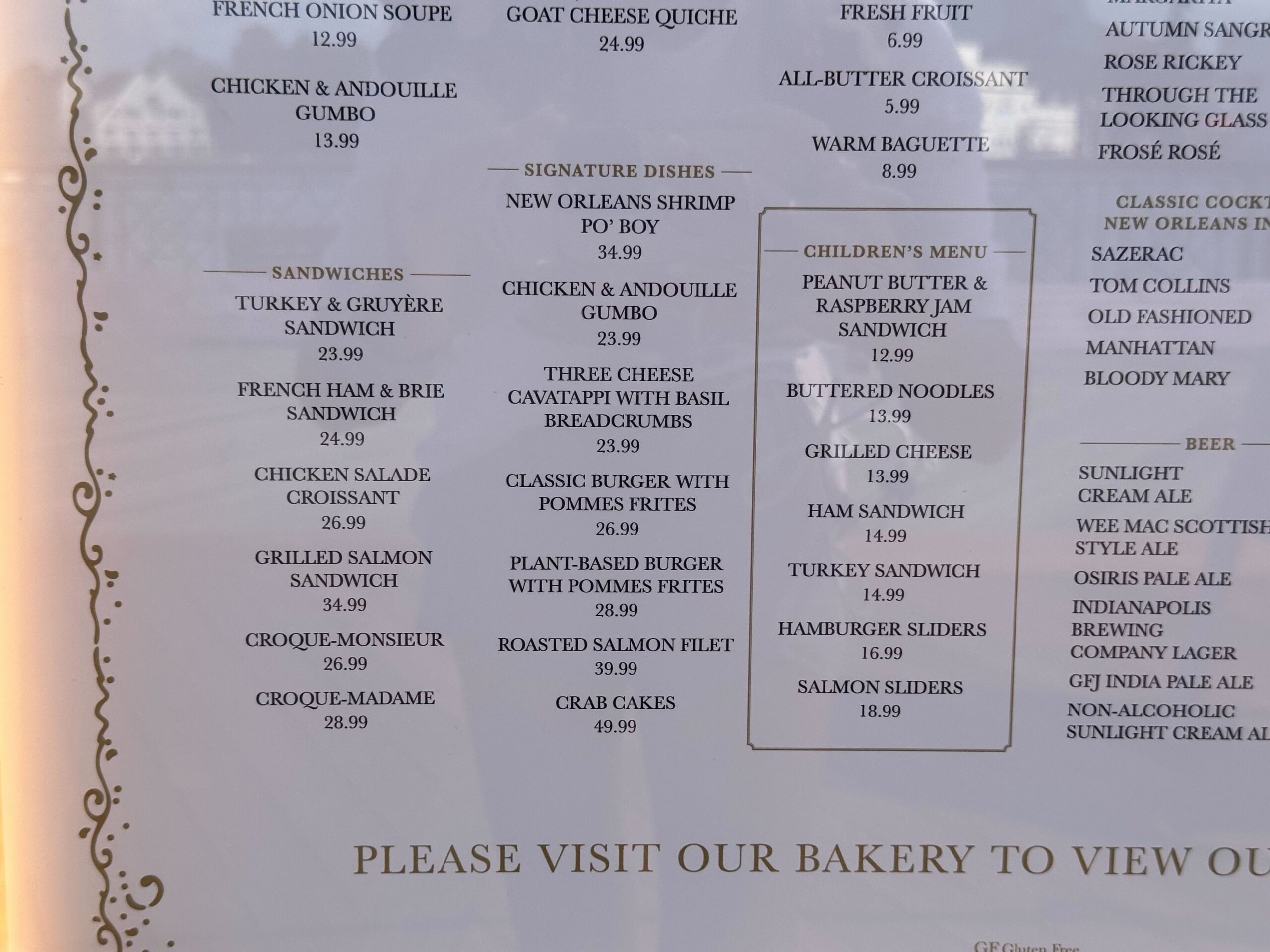 Menu displaying various dishes, including sandwiches, burgers, seafood, children's meals, sides, and desserts from the cake bake shop, with prices listed.