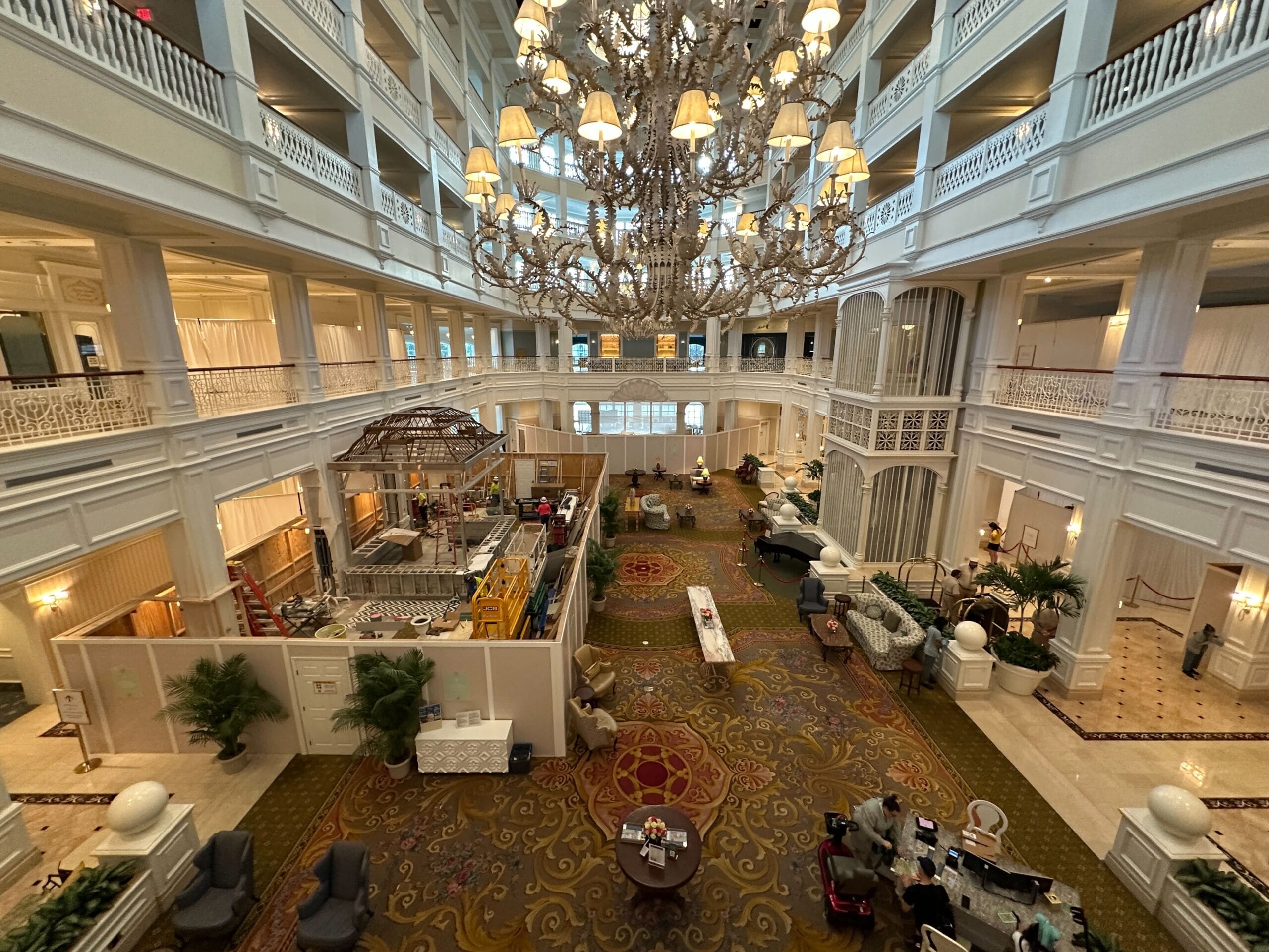 Large, elegant hotel lobby with a grand chandelier, high ceilings, and ongoing construction on the lower level.