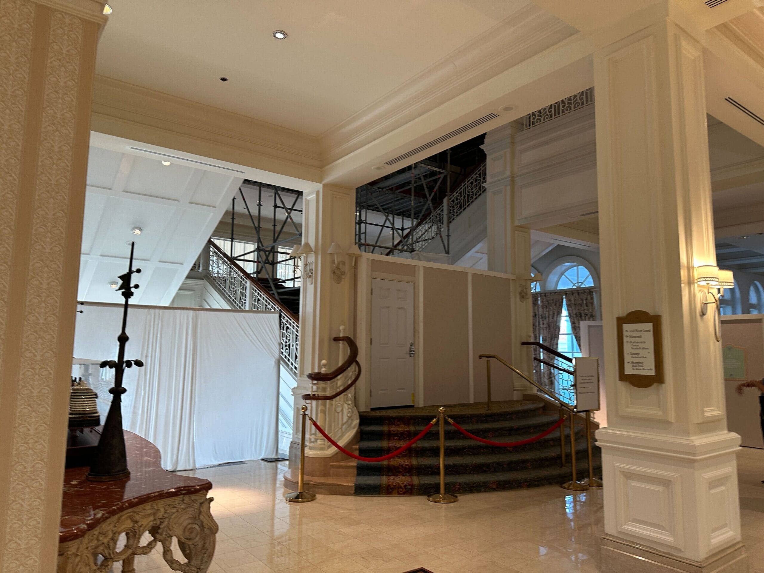 A staircase closed off by barriers and construction walls inside the Grand Floridian lobby. 