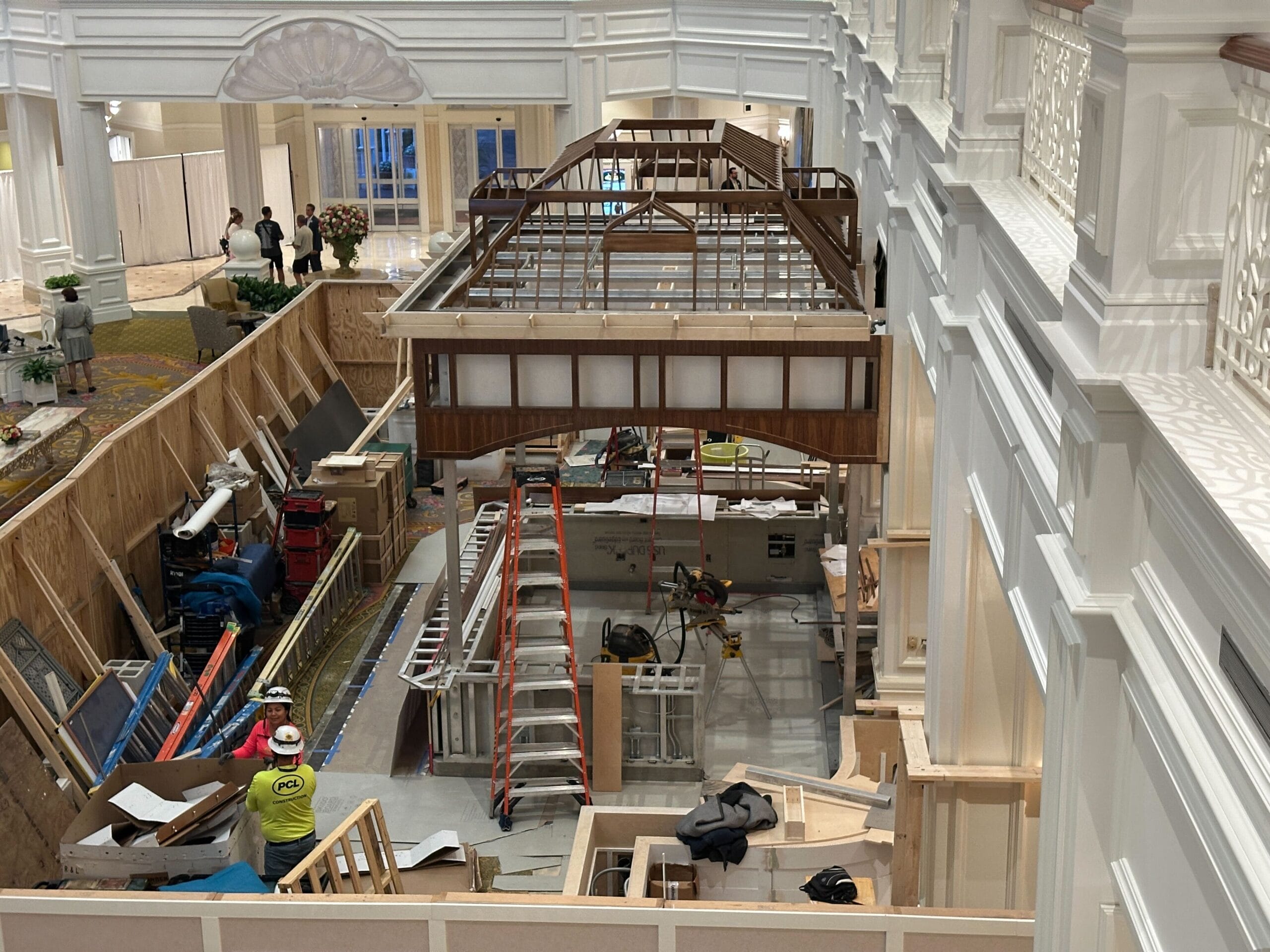 Large indoor construction site with workers and tools inside the Grand Floridian luxury hotel at Disney Resort.