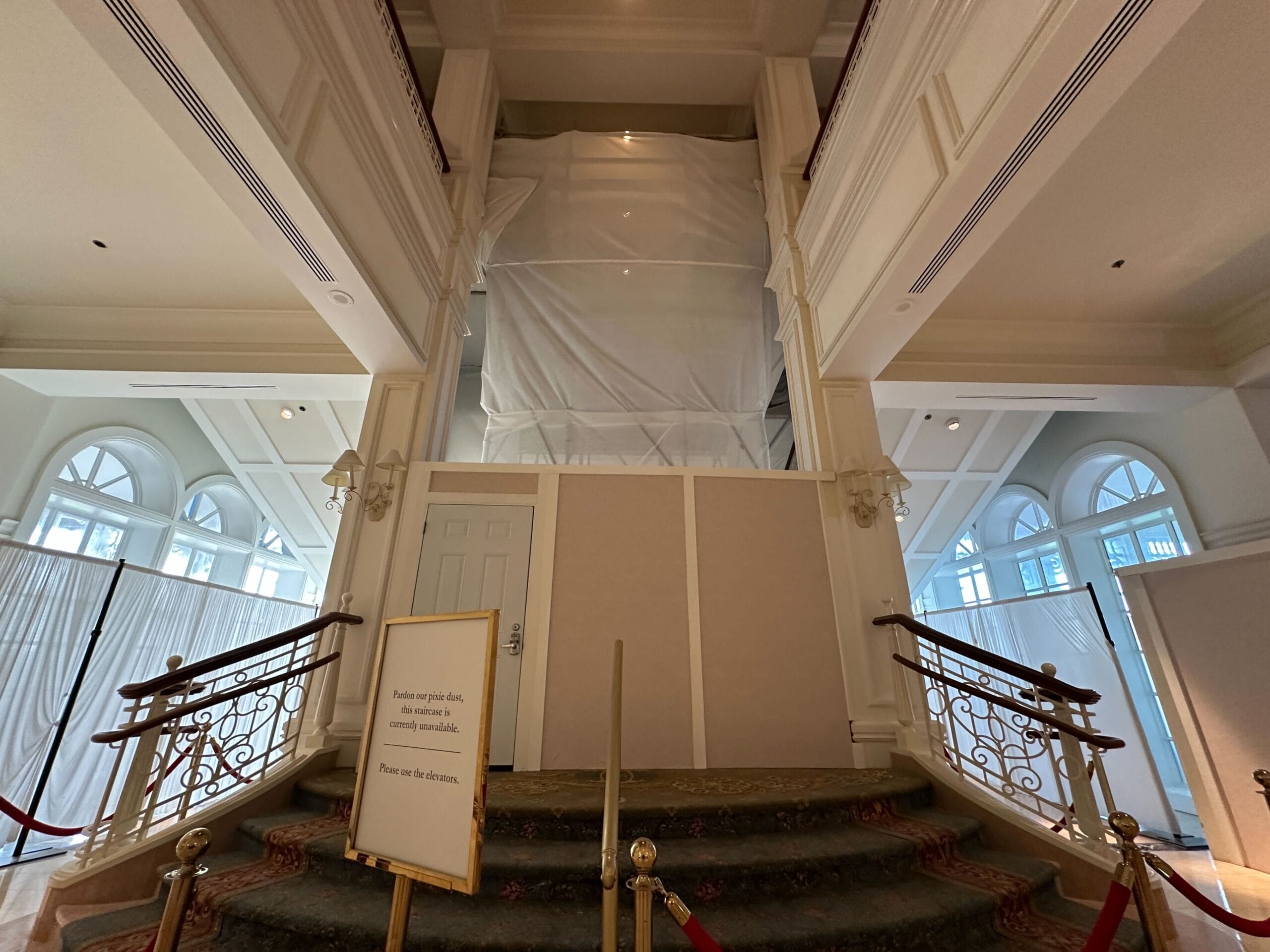Grand Floridian construction blocks the grand staircase with barriers and sheeting near the tea room entrance.