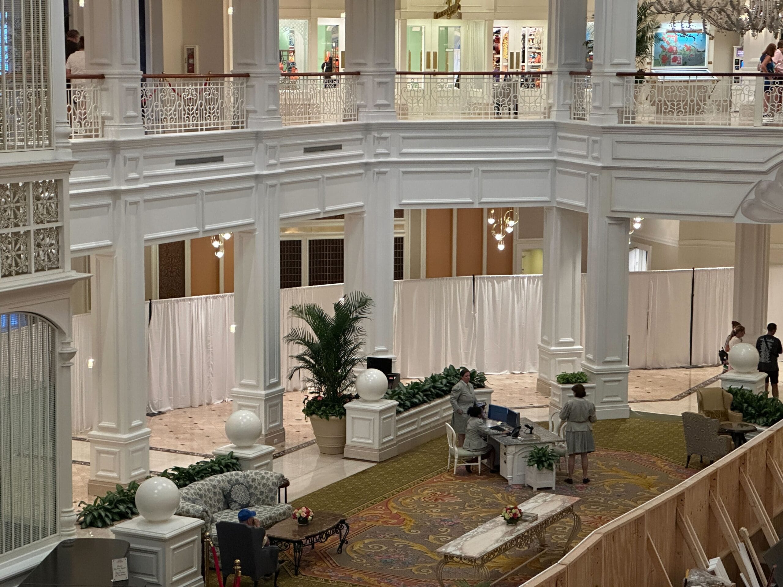A pianist plays at a grand piano in the Grand Floridian’s white lobby with high ceilings and people nearby.