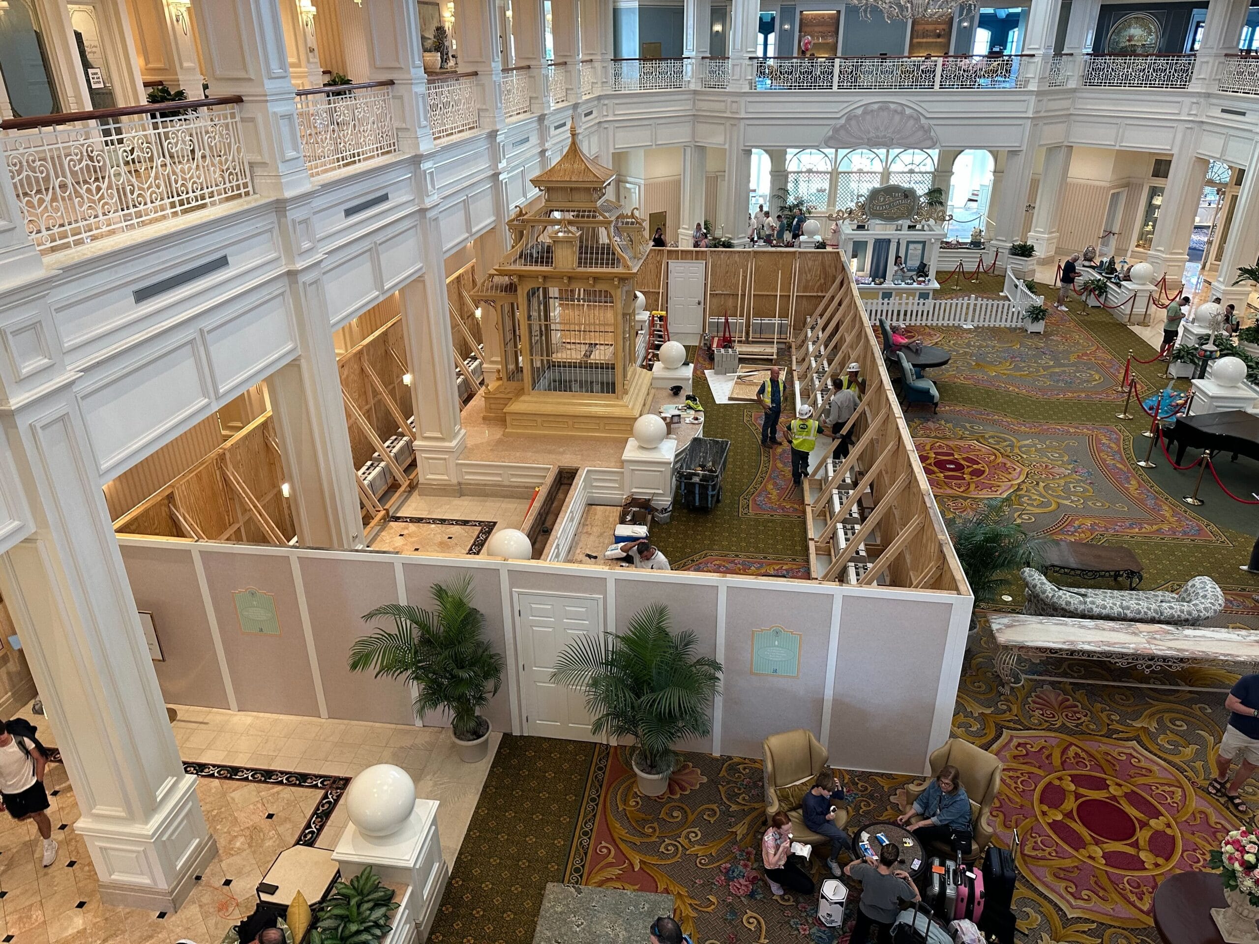 The Grand Floridian lobby features ornate decor and high ceilings amid lobby construction and guests seated nearby.