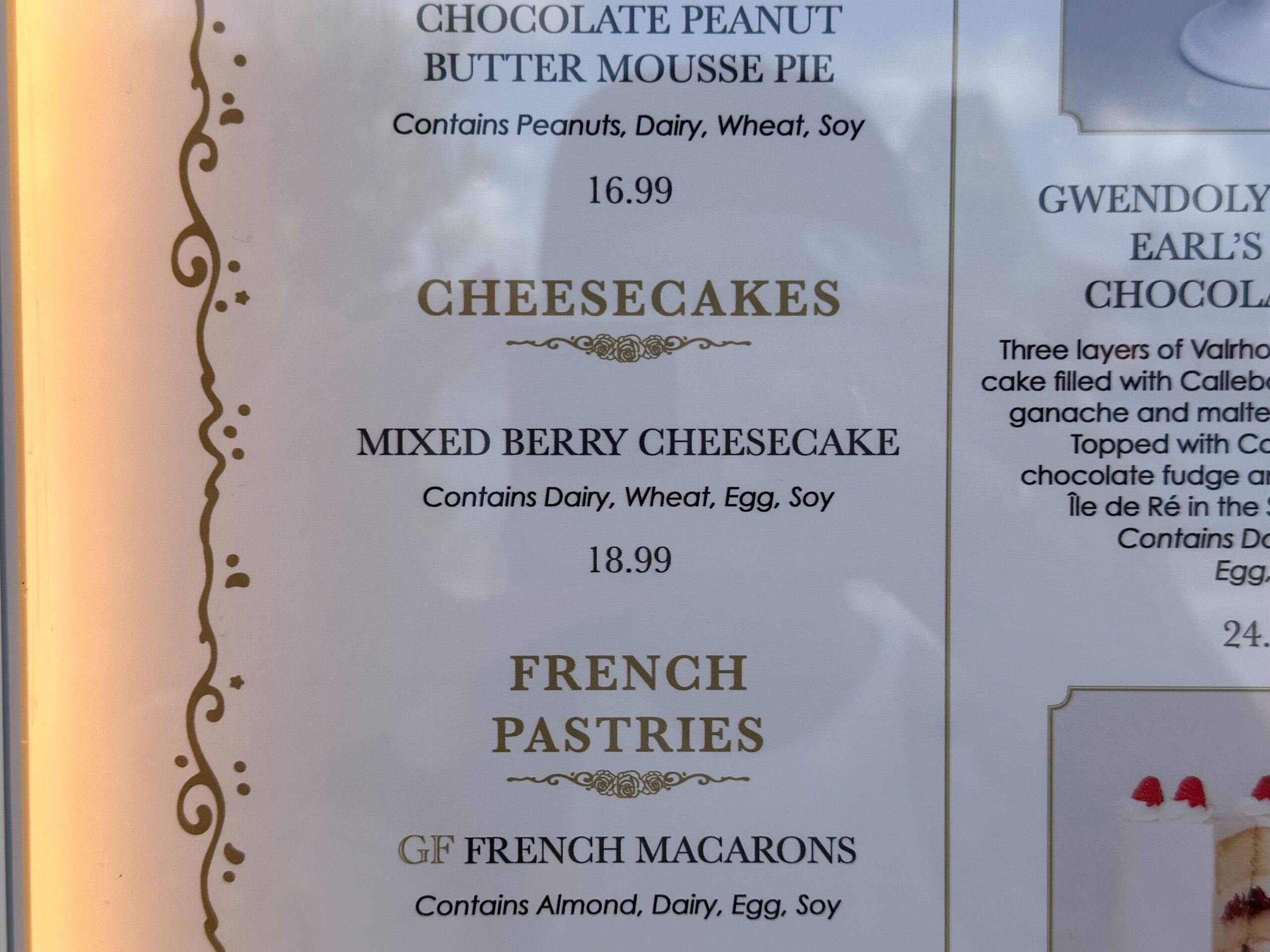 Explore our delectable menu from the Cake Bake Shop, featuring Chocolate Peanut Butter Mousse Pie, Mixed Berry Cheesecake, and French Pastries, including GF French Macarons. Prices and allergen information are thoughtfully provided for your convenience.
