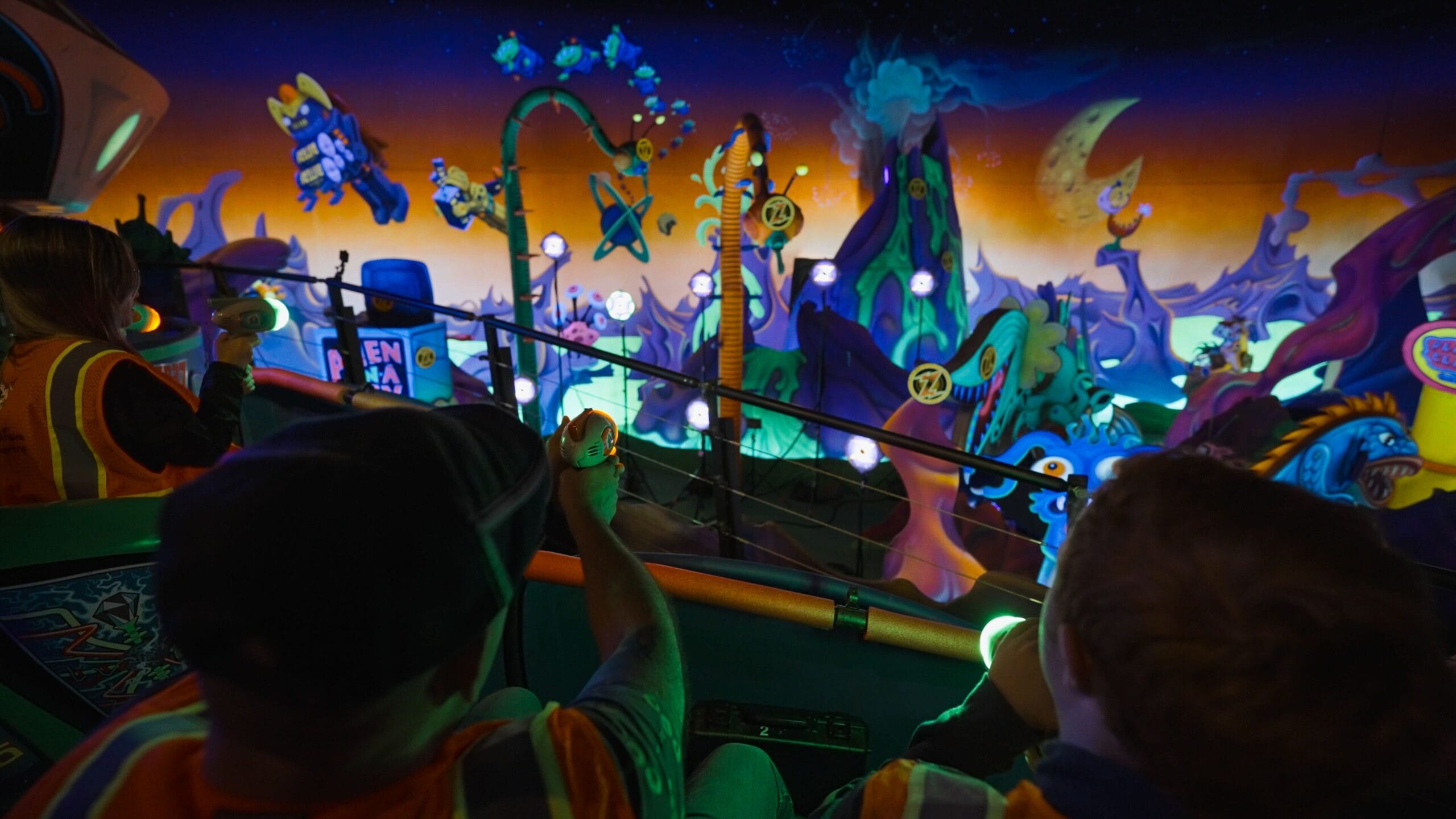 Visitors at the Magic Kingdom enjoy a thrilling ride while clutching their toy prizes, set against a vibrant, space-themed backdrop filled with planets and rockets. It feels like they're on Buzz Lightyear's Space Ranger Spin, surrounded by playful aliens.
