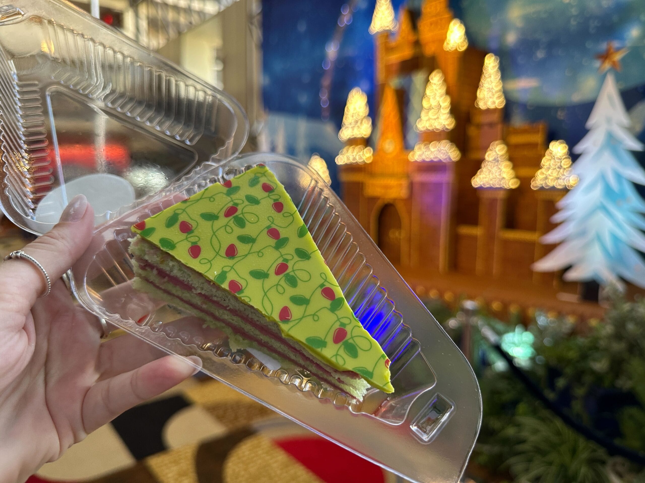 The pistachio is covered in a green layer adorned with Christmas lights.