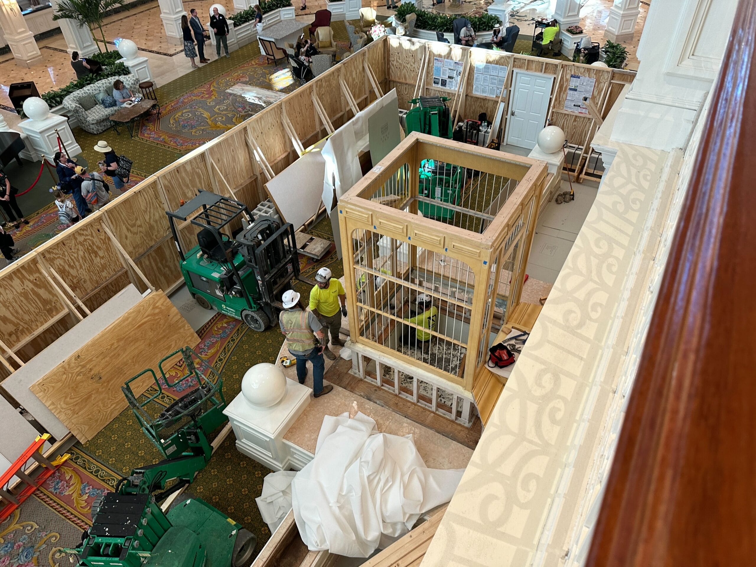 Bird's-eye view of the Grand Floridian Resort lobby remodel, showing workers, equipment, and wooden barriers.