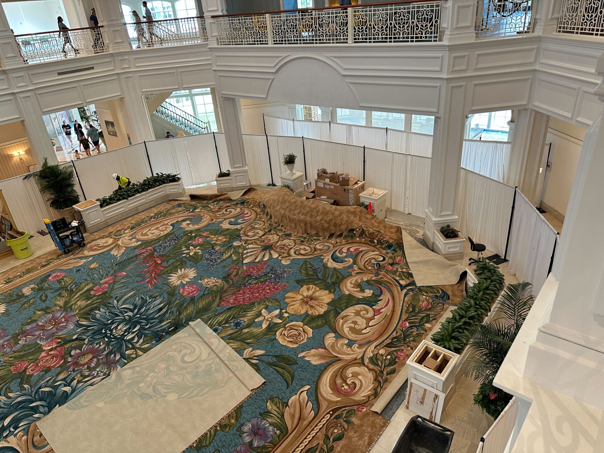 The Grand Floridian Lobby at Walt Disney World is under renovation, floral carpets visible, with supplies and boxes around.
