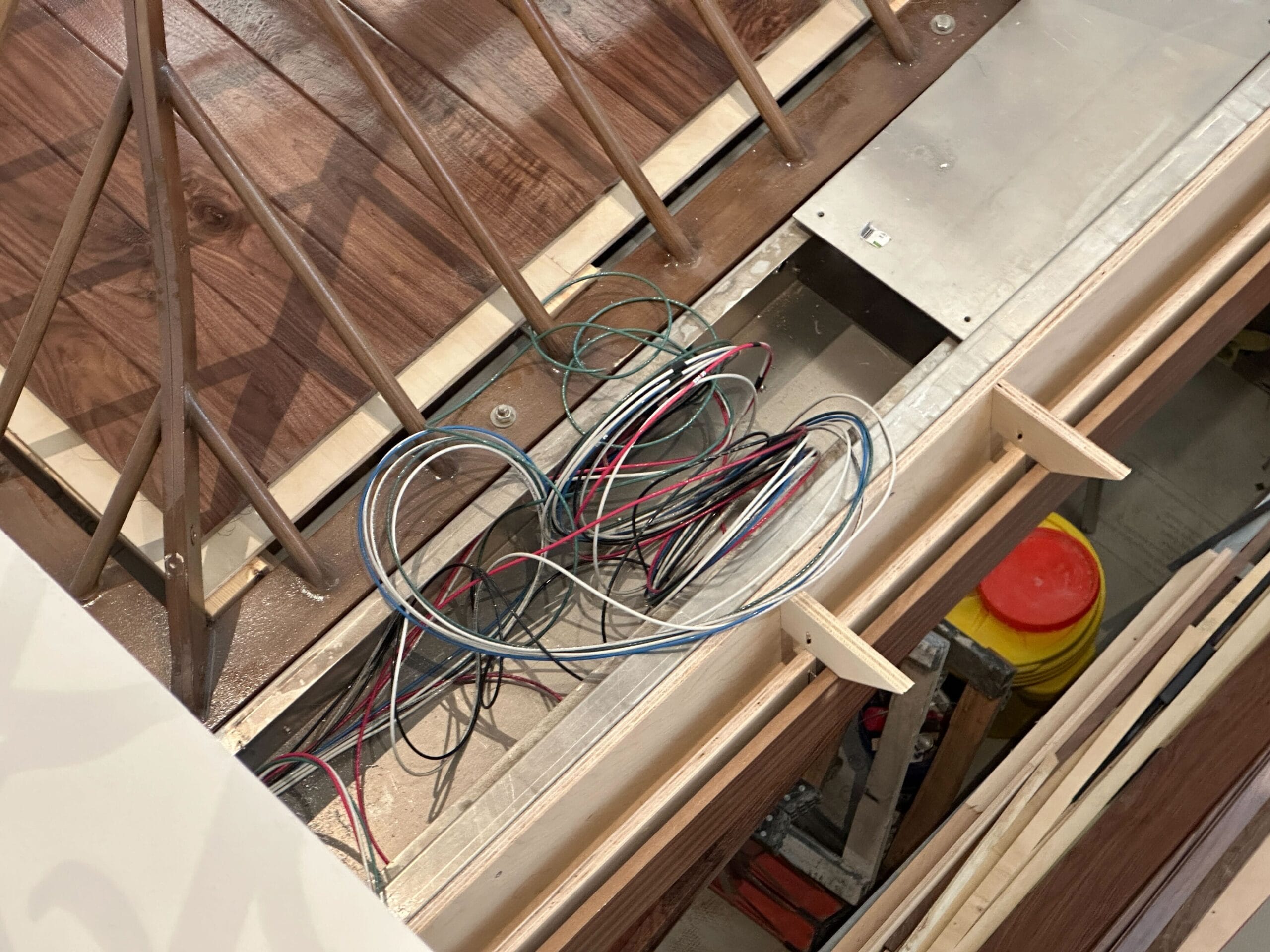 Loose electrical wires are coiled inside a wooden floor under construction, like the careful prep behind a Disneyland castle renovation.