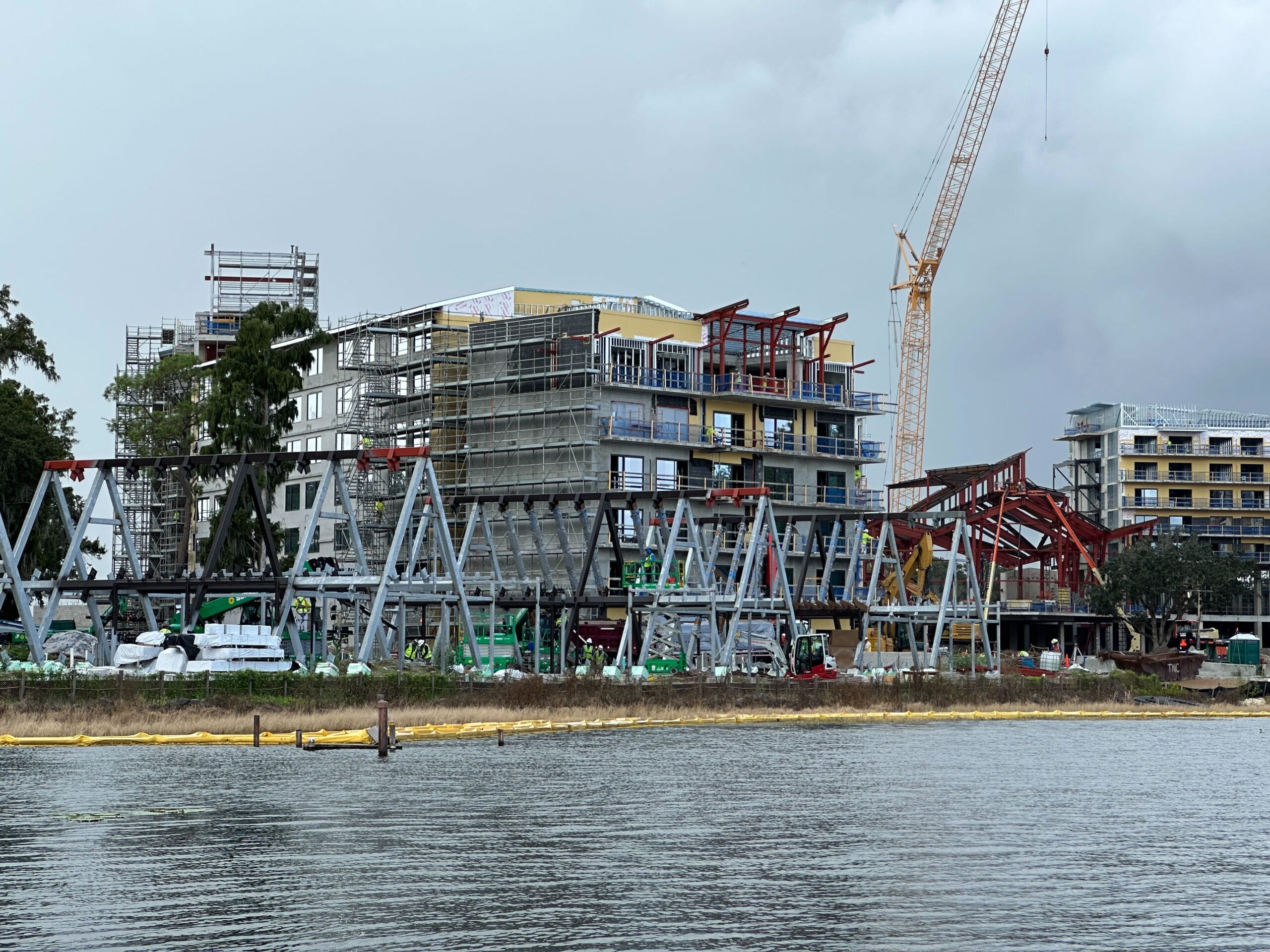Construction updates: Lakeshore Lodge rises near the water, cranes and scaffolding shaping its multi-story frame.