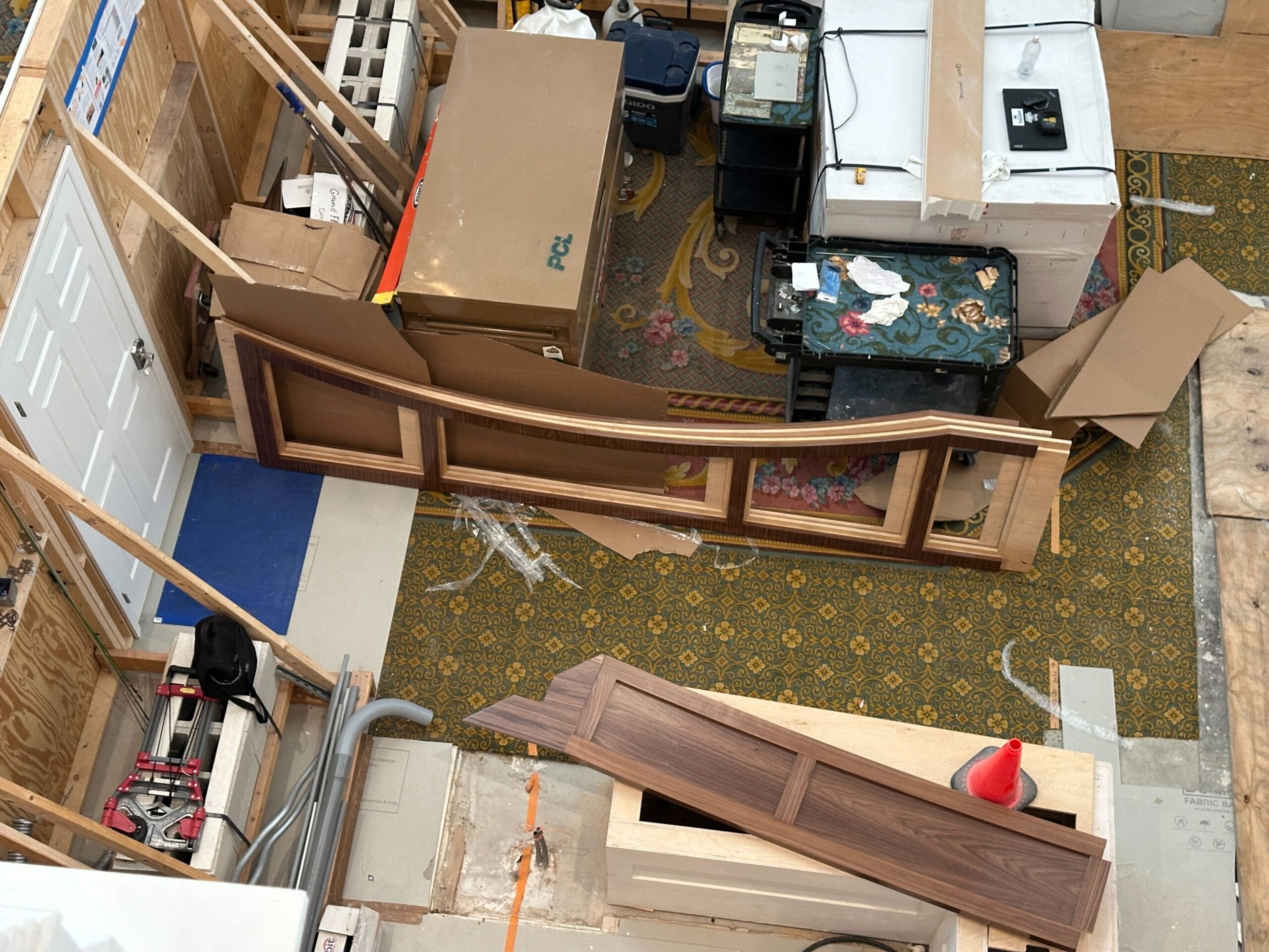 View of a construction area at Grand Floridian Resort with wood panels, cables, and tools on a patterned carpet.