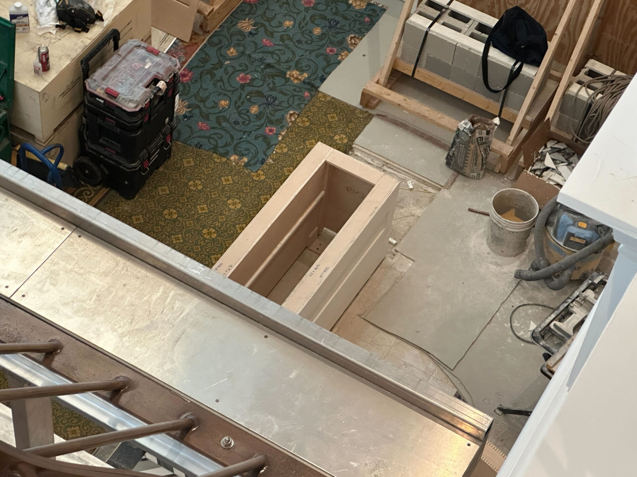 A construction area in the Grand Floridian lobby with tools, boxes, carpet, and a decorative panel on the floor.