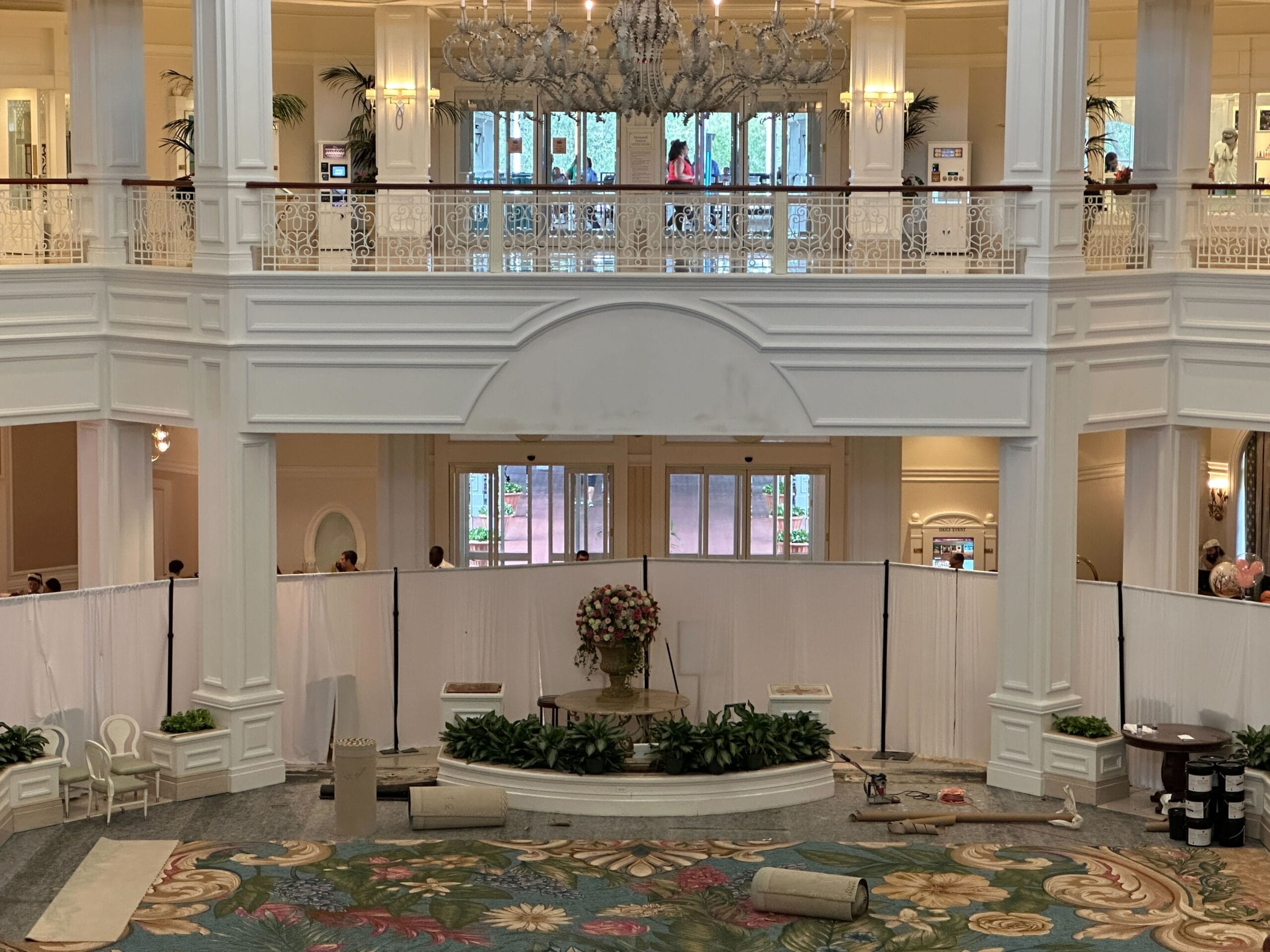 Grand Floridian Lobby at Walt Disney World with white curtains, plush carpet, and a central flower display—classic Disney elegance.