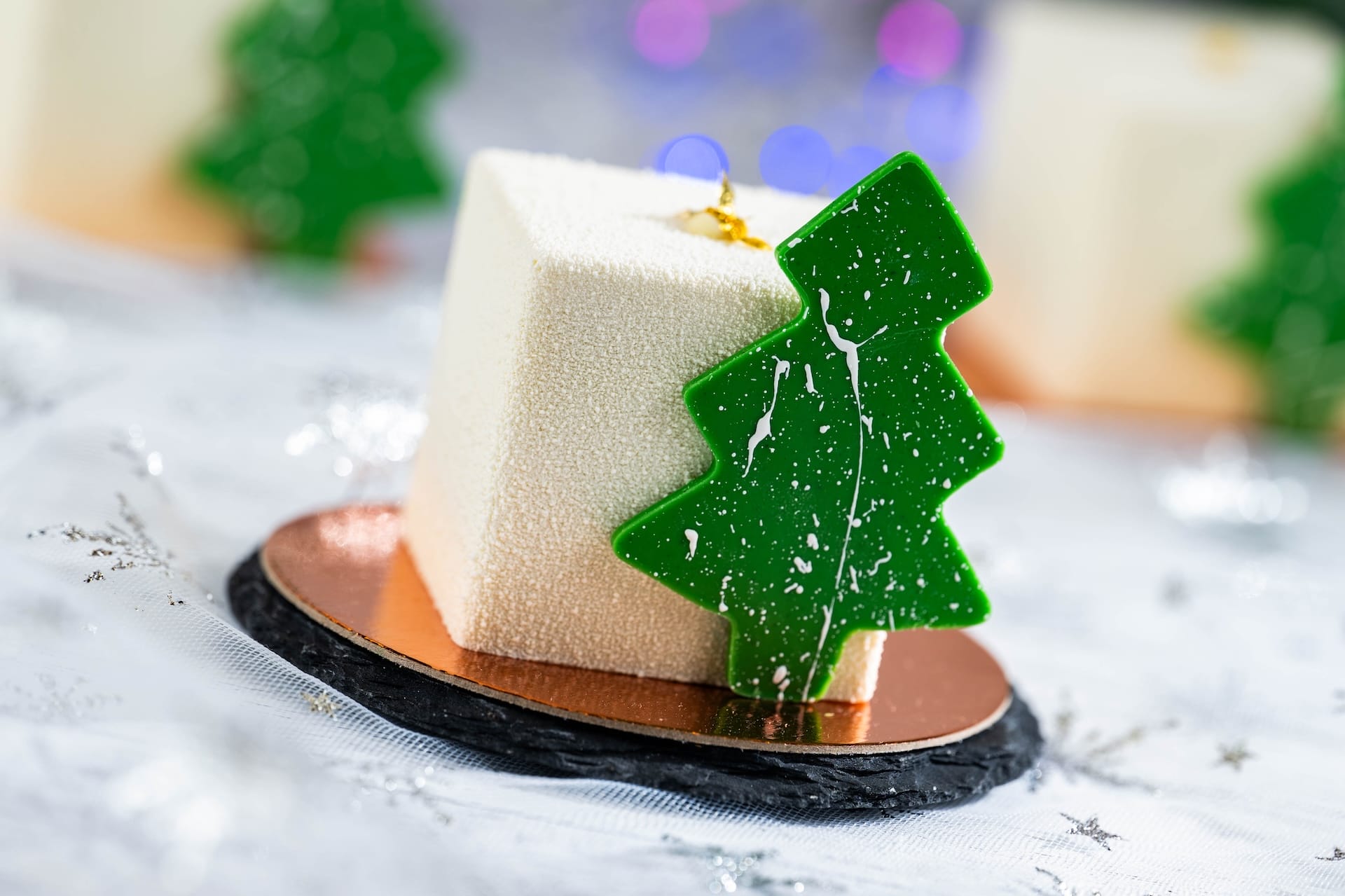 A square white dessert topped with a green Christmas tree, festive for 2025 holidays at Walt Disney World—no castle in view.