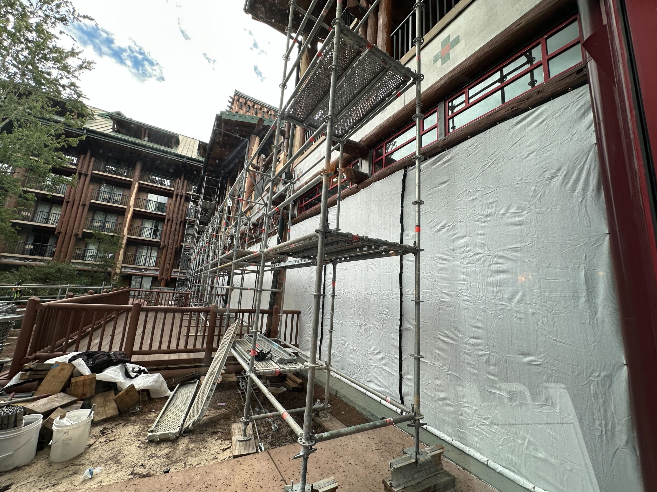 Scaffolding stands against Wilderness Lodge under renovation, with construction materials scattered nearby.