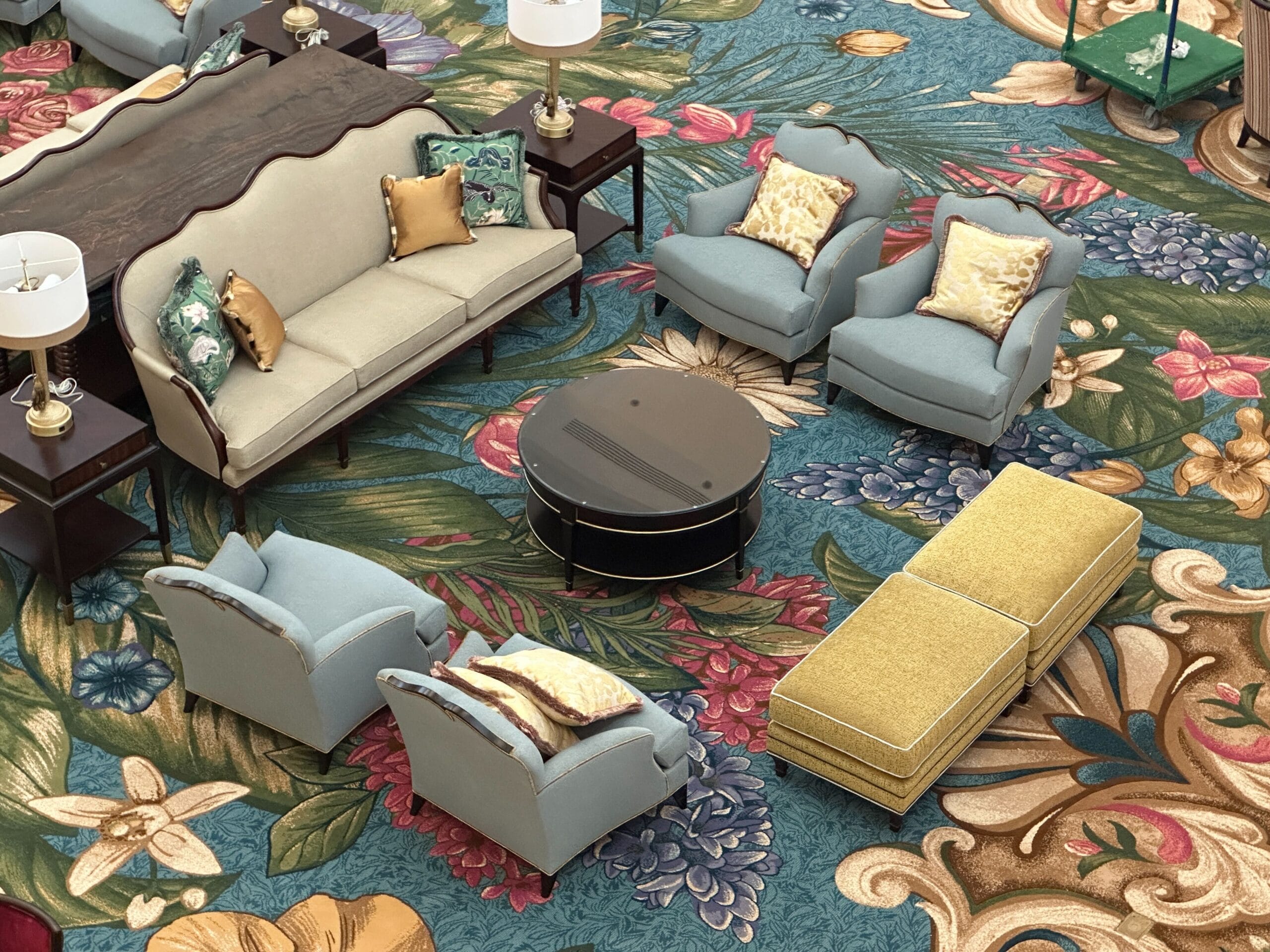 Elegant seating area with blue chairs and beige sofa, featuring lobby decor reminiscent of Disney's Grand Floridian Resort.