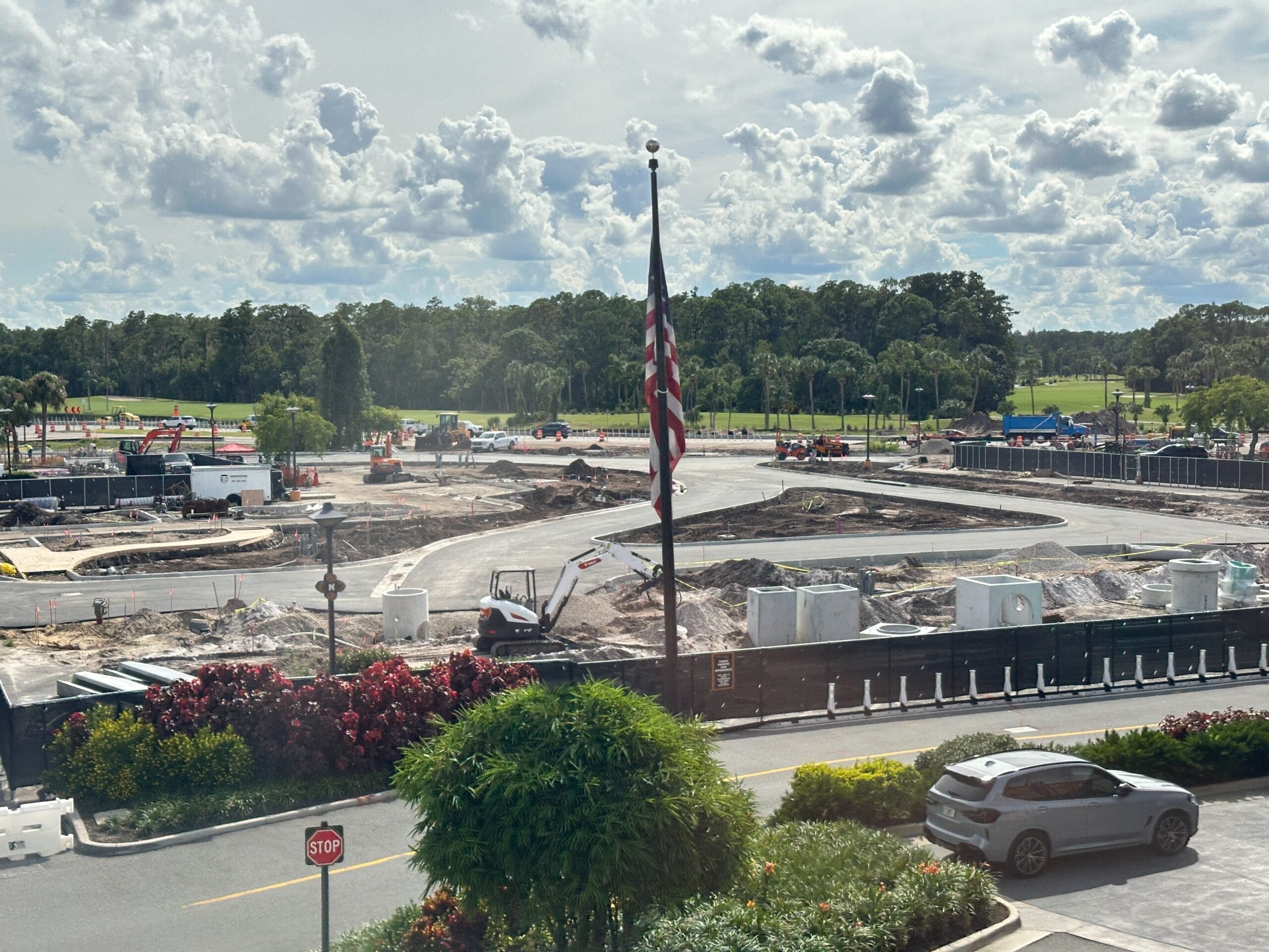 A construction site at Disney's Polynesian Village Resort with vehicles, dirt piles, and a cloudy sky in the background.