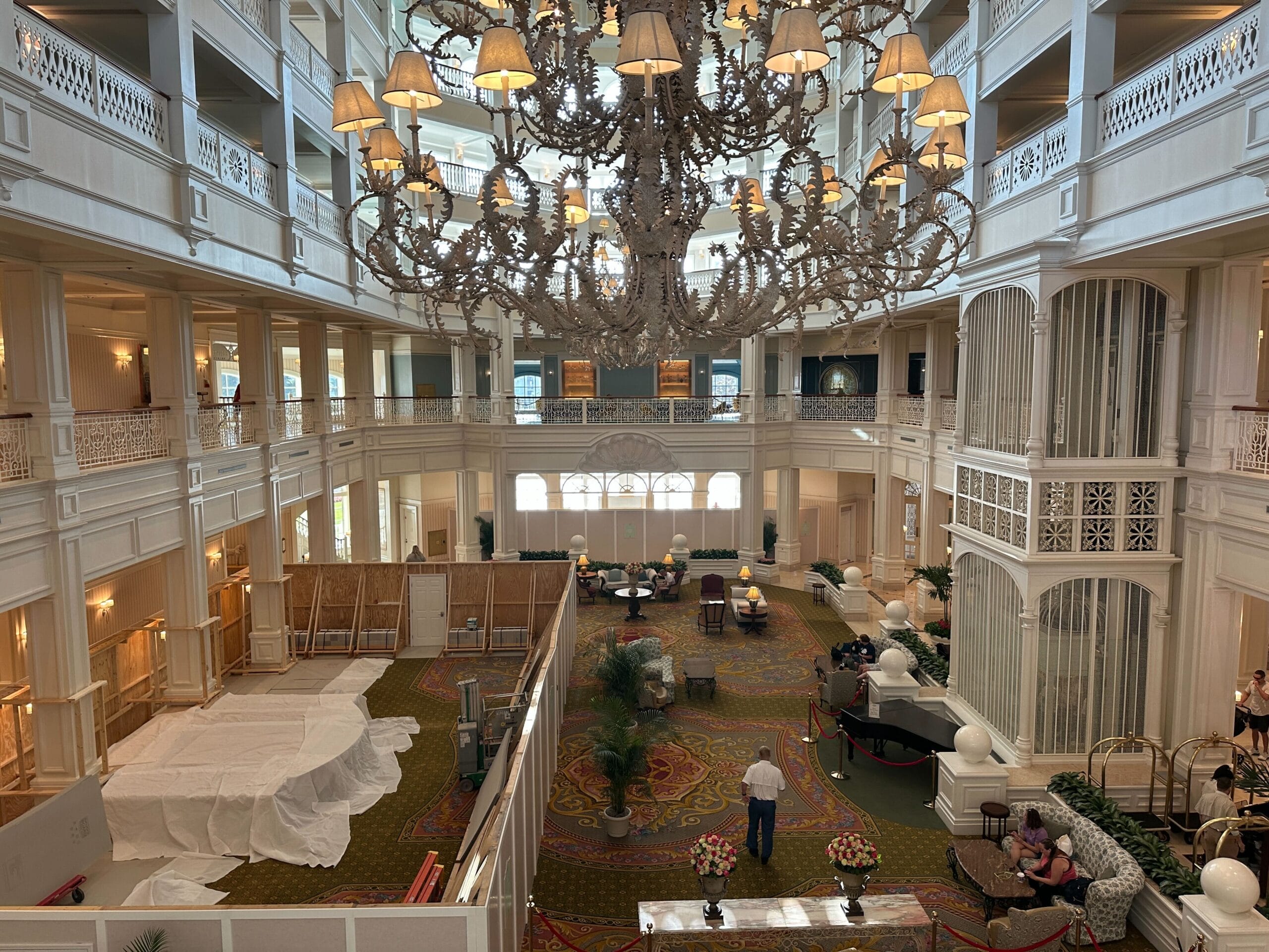 Grand hotel lobby with elegant white decor, chandelier, and areas under renovation—like a scene after H2O Glow After Hours food fest.