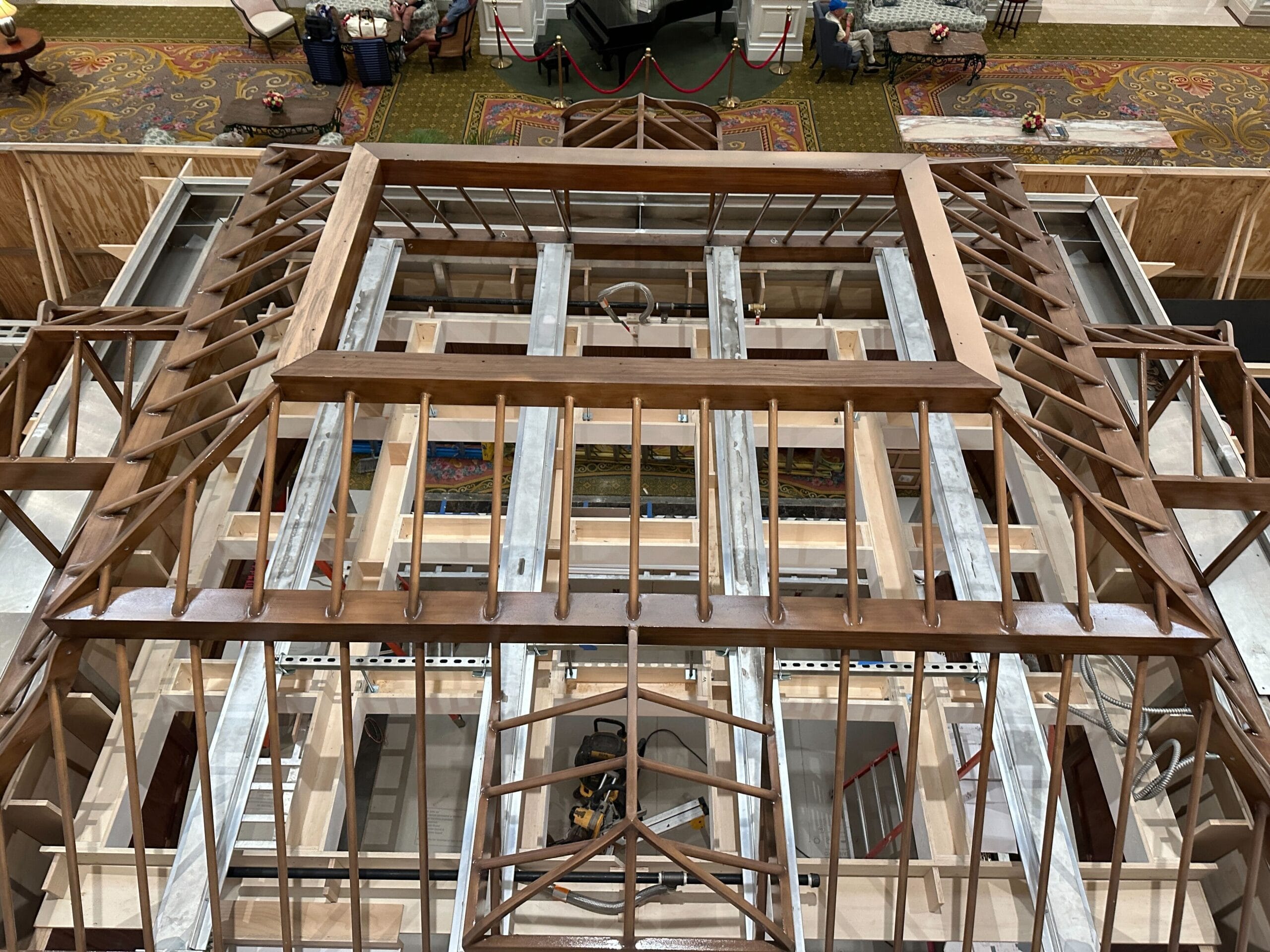Overhead view of a wooden roof frame under construction at Grand Floridian, beams and supports visible indoors.