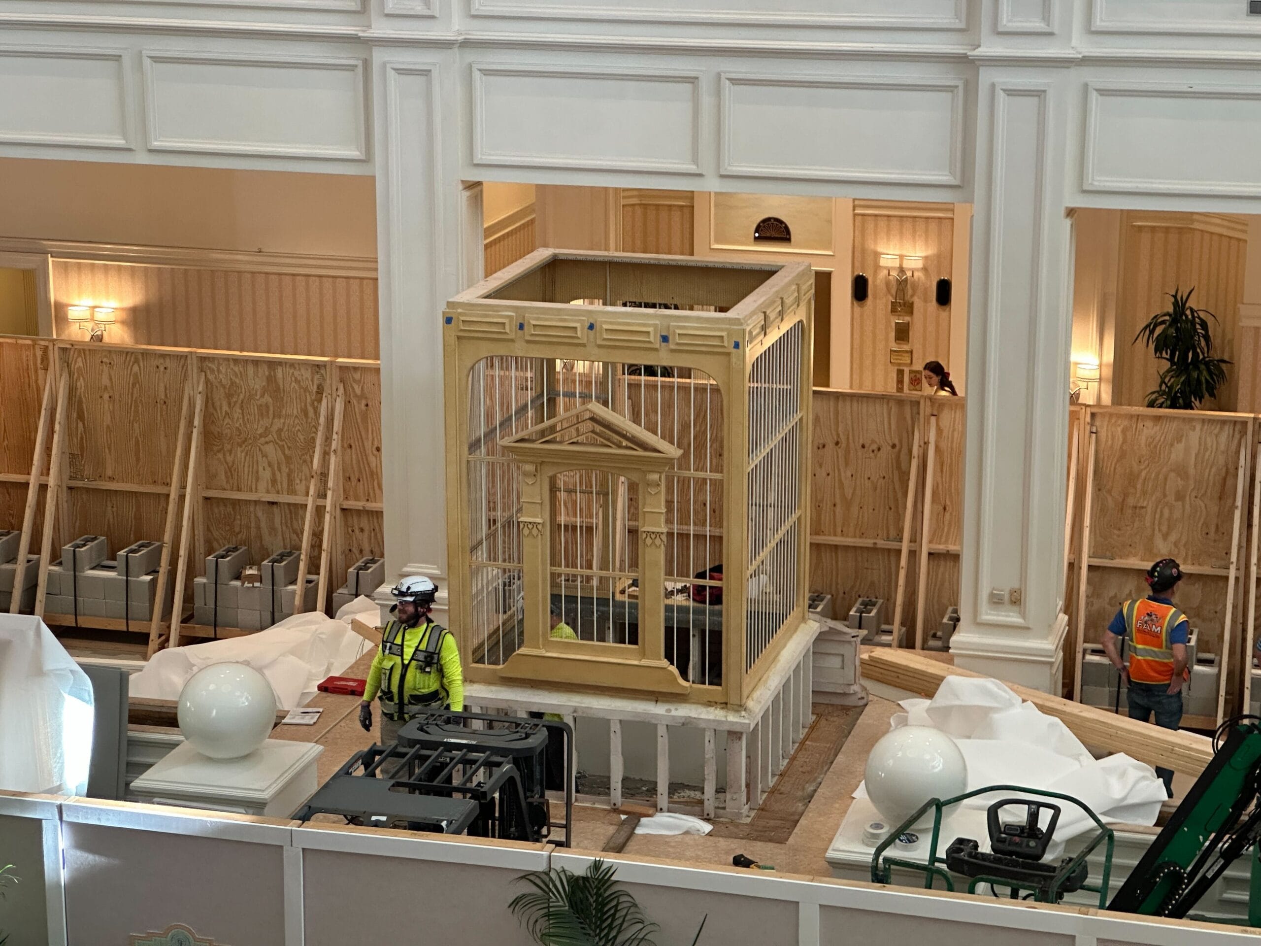 Construction workers install a large, wooden birdcage-like structure during the Grand Floridian Resort lobby remodel.