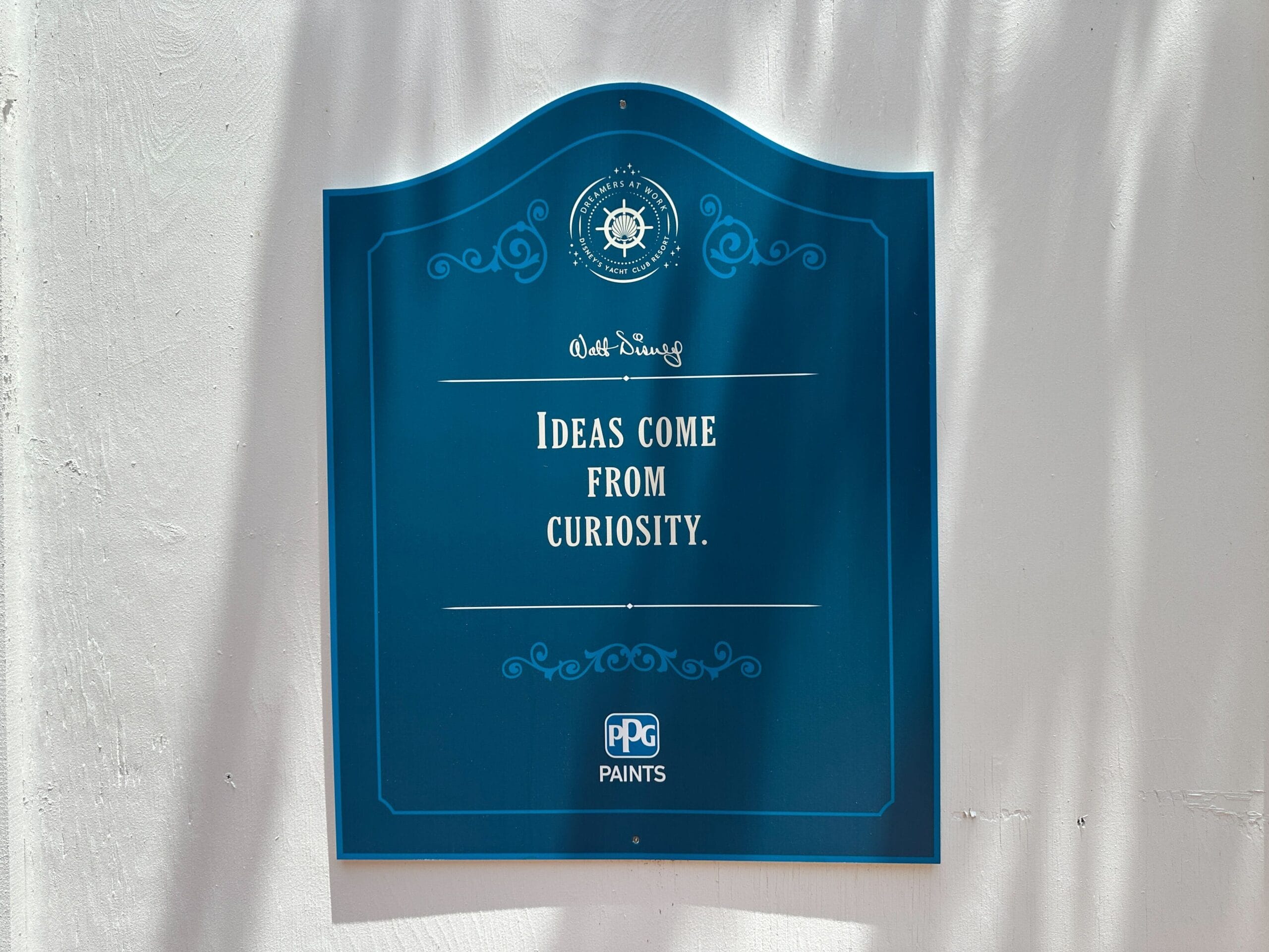 A blue sign reads, Ideas come from curiosity.—Walt Disney, with PPG Paints logo at the bottom.