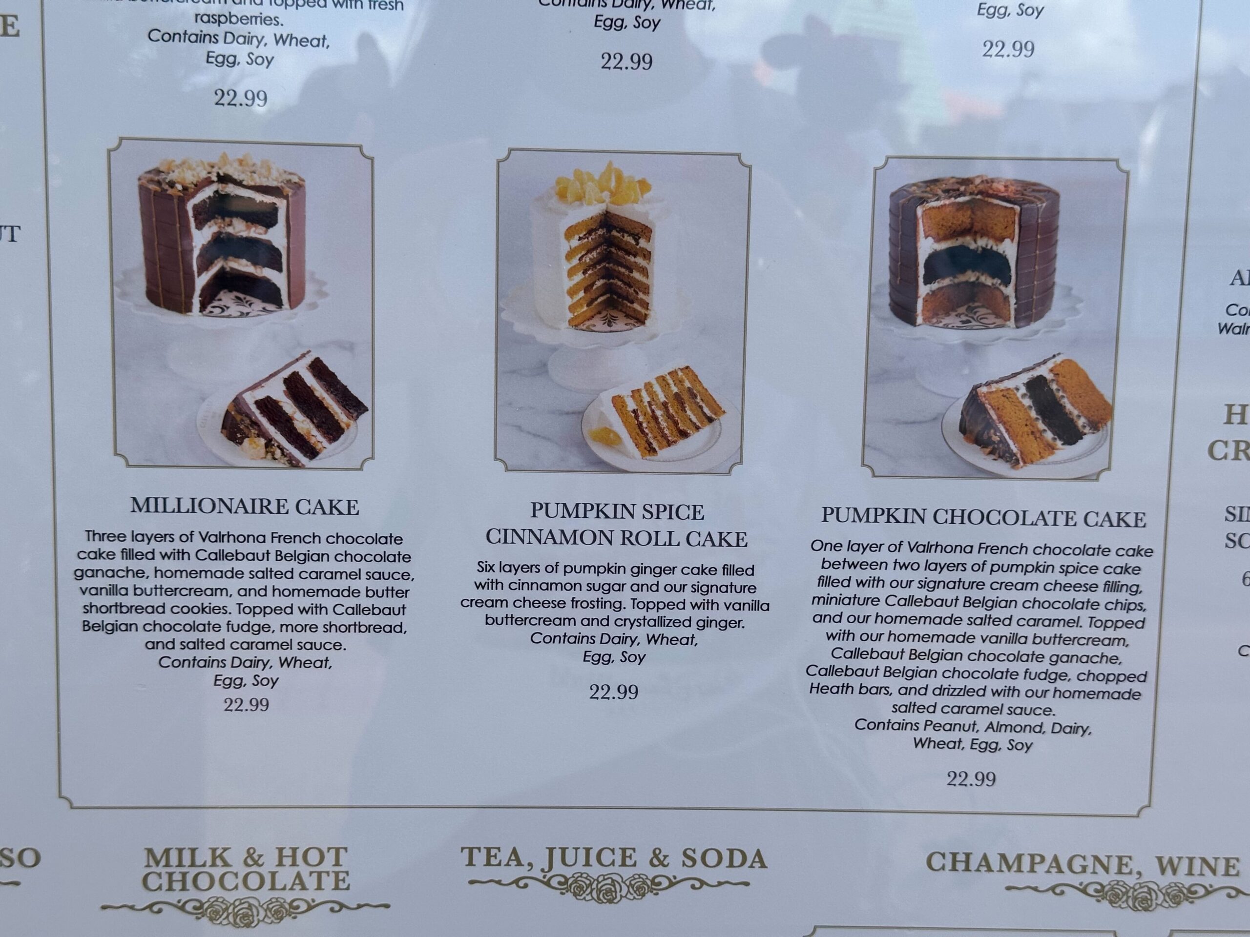 Menu display from a charming cake bake shop featuring images and descriptions of three delectable cakes: Millionaire Cake, Pumpkin Spice Cinnamon Roll Cake, and Pumpkin Chocolate Cake, each beautifully priced at $22.99.