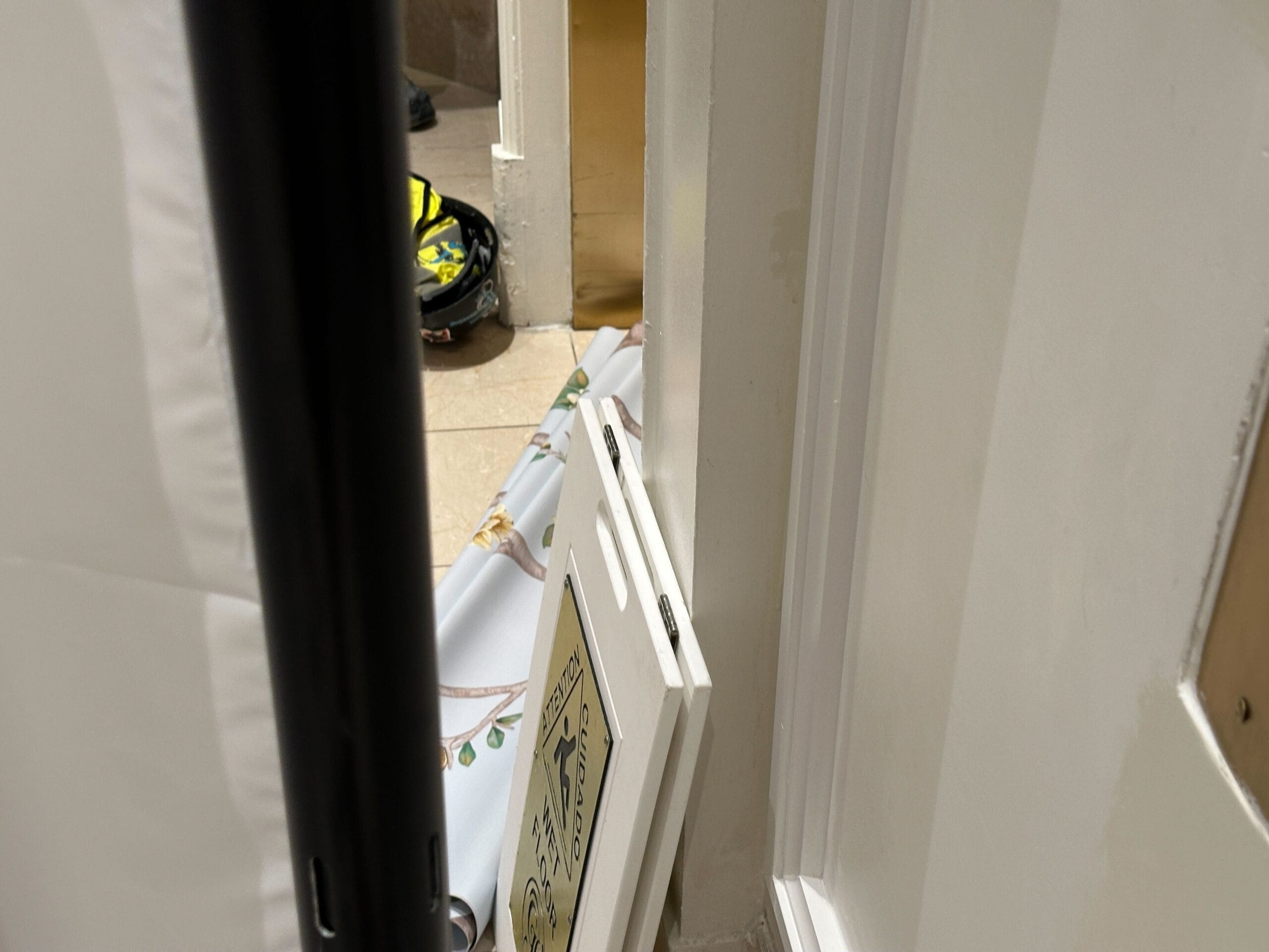 Two white panels leaned against a wall in the lobby, with a floor mat and helmet in view at Disney's Grand Floridian Resort.