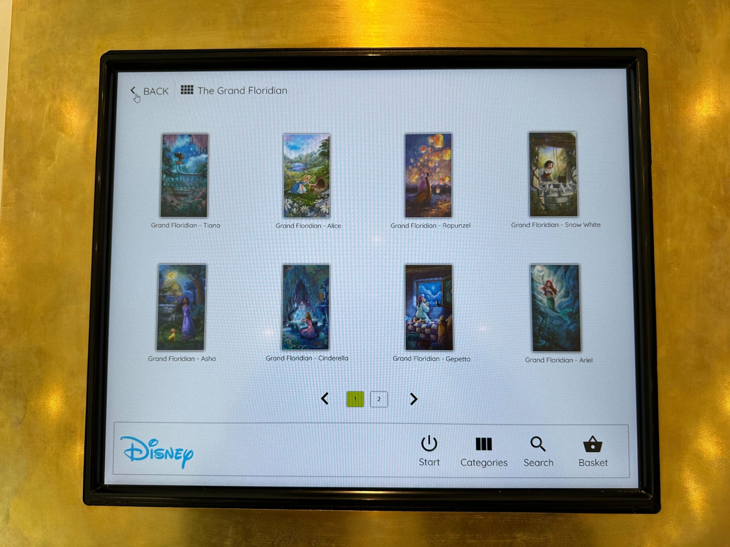 A touchscreen at the Grand Floridian Resort displays eight Disney-themed artwork thumbnails, each labeled with a character name. The options include Tiana, Alice, Rapunzel, Snow White, Ariel, and others. Indulge in this captivating digital art experience during your stay.