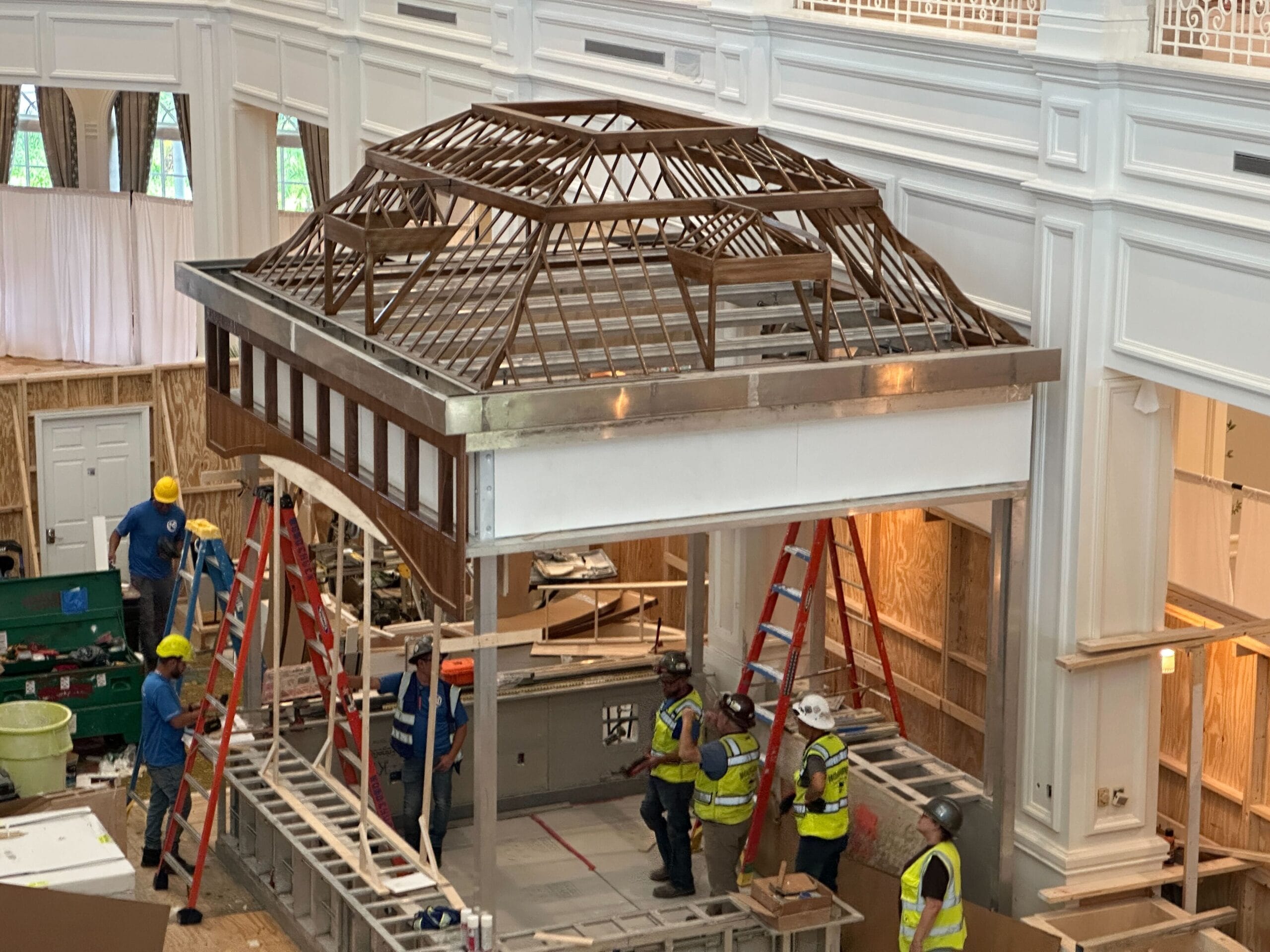 Construction workers install a wooden roof frame and new light fixtures at Disney’s Grand Floridian Resort.