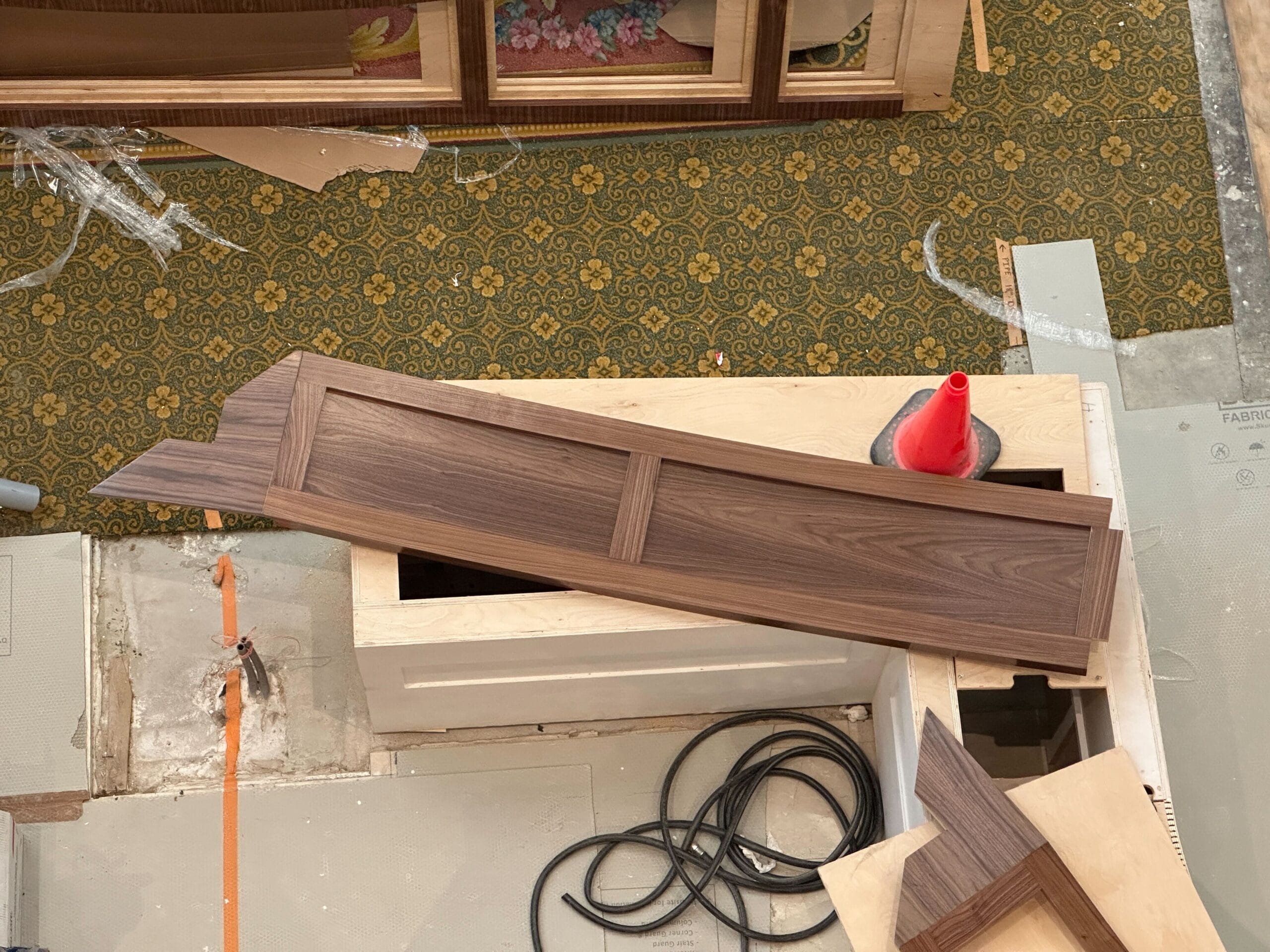 A wooden panel with angled ends rests on a box near new light fixtures at Disney's Grand Floridian Resort.
