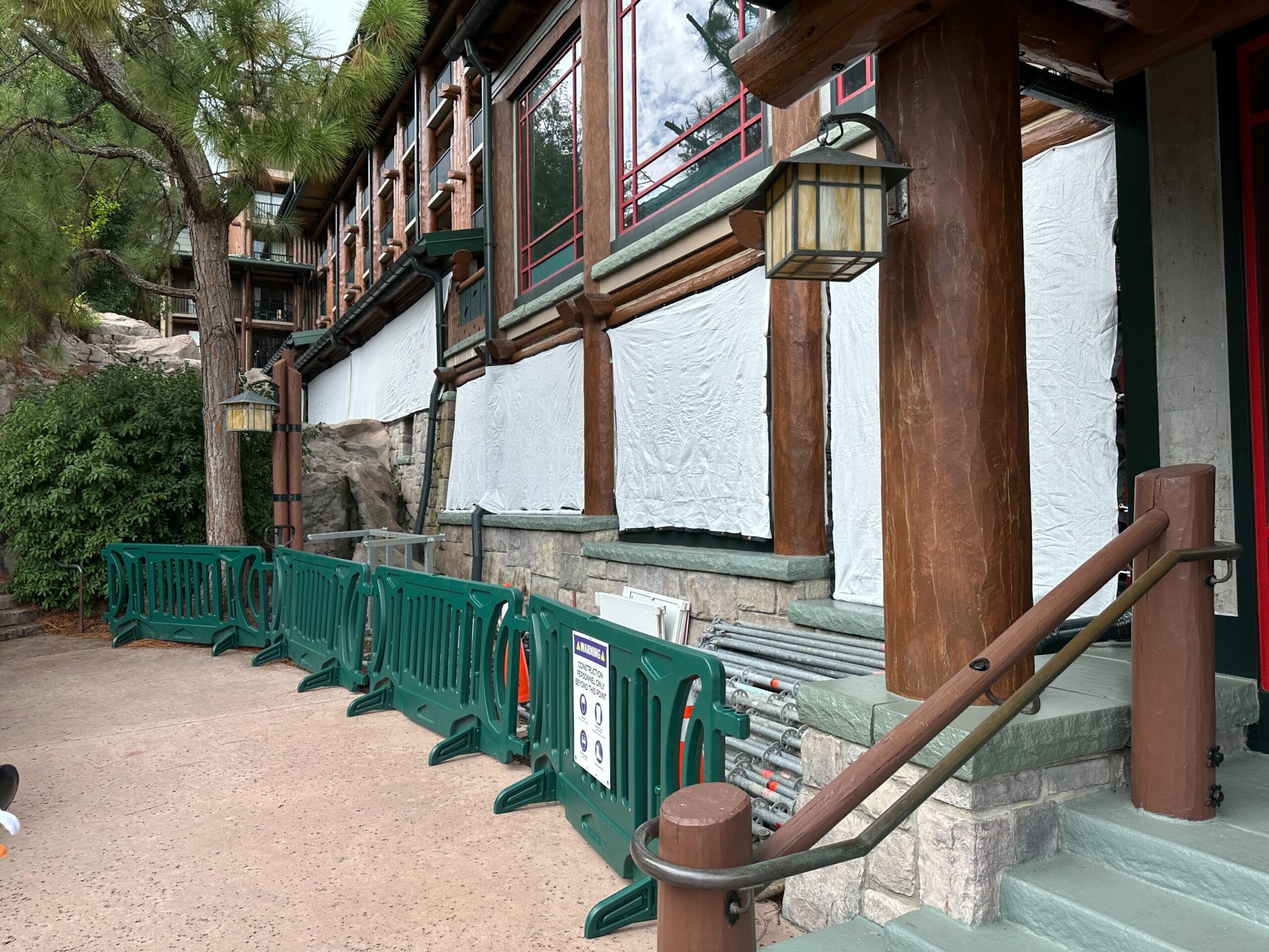 A building under renovation at Wilderness Lodge with windows covered and green barriers blocking off the area.