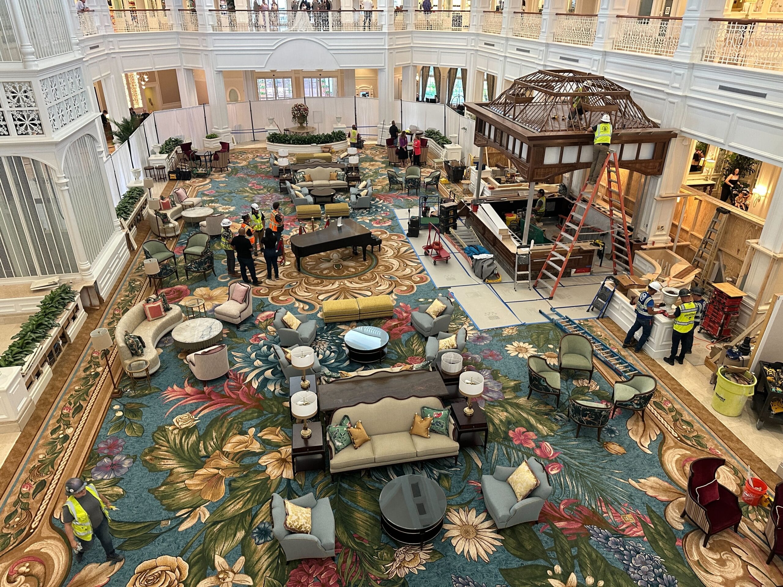 Grand Floridian Resort lobby at Walt Disney World, with floral carpet, elegant furniture, staff in vests, and construction zone.