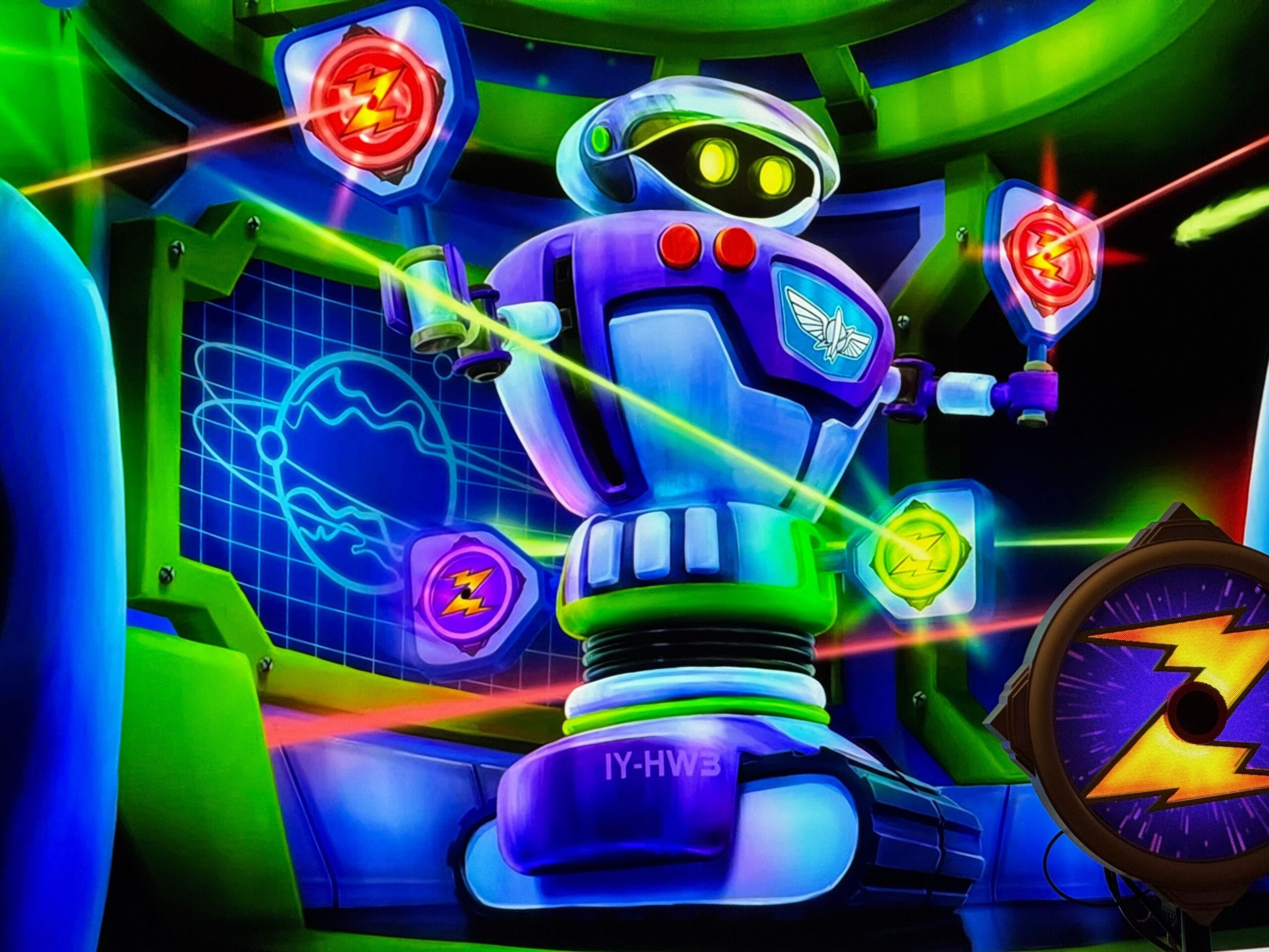 A colorful robotic figure with glowing eyes stands in a futuristic setting, surrounded by neon symbols and lasers. A control panel with various indicators is visible beside it.