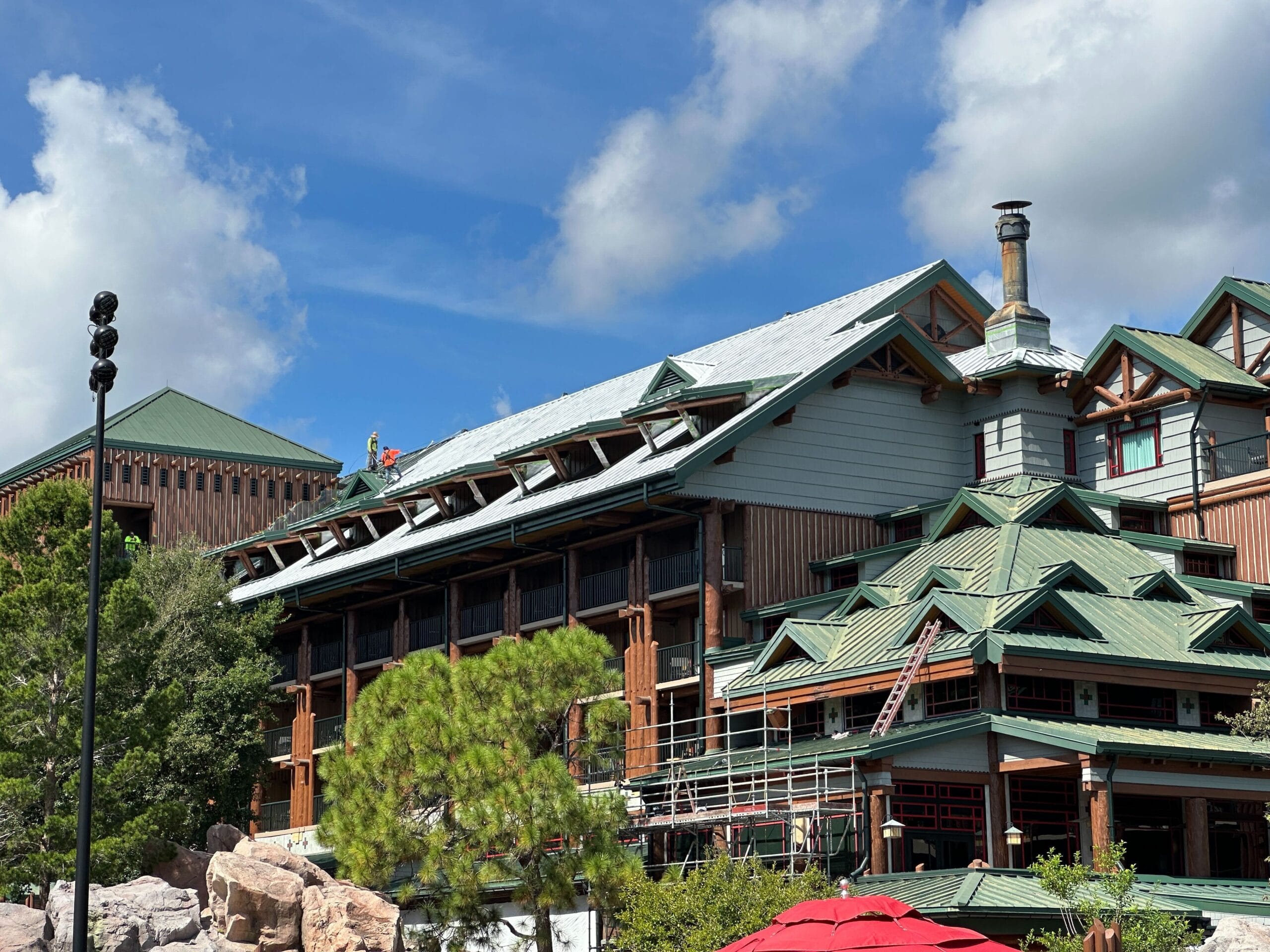 A rustic Fort Wilderness Lodge building with green roofs, wood accents, and scaffolding hints at an exciting update.
