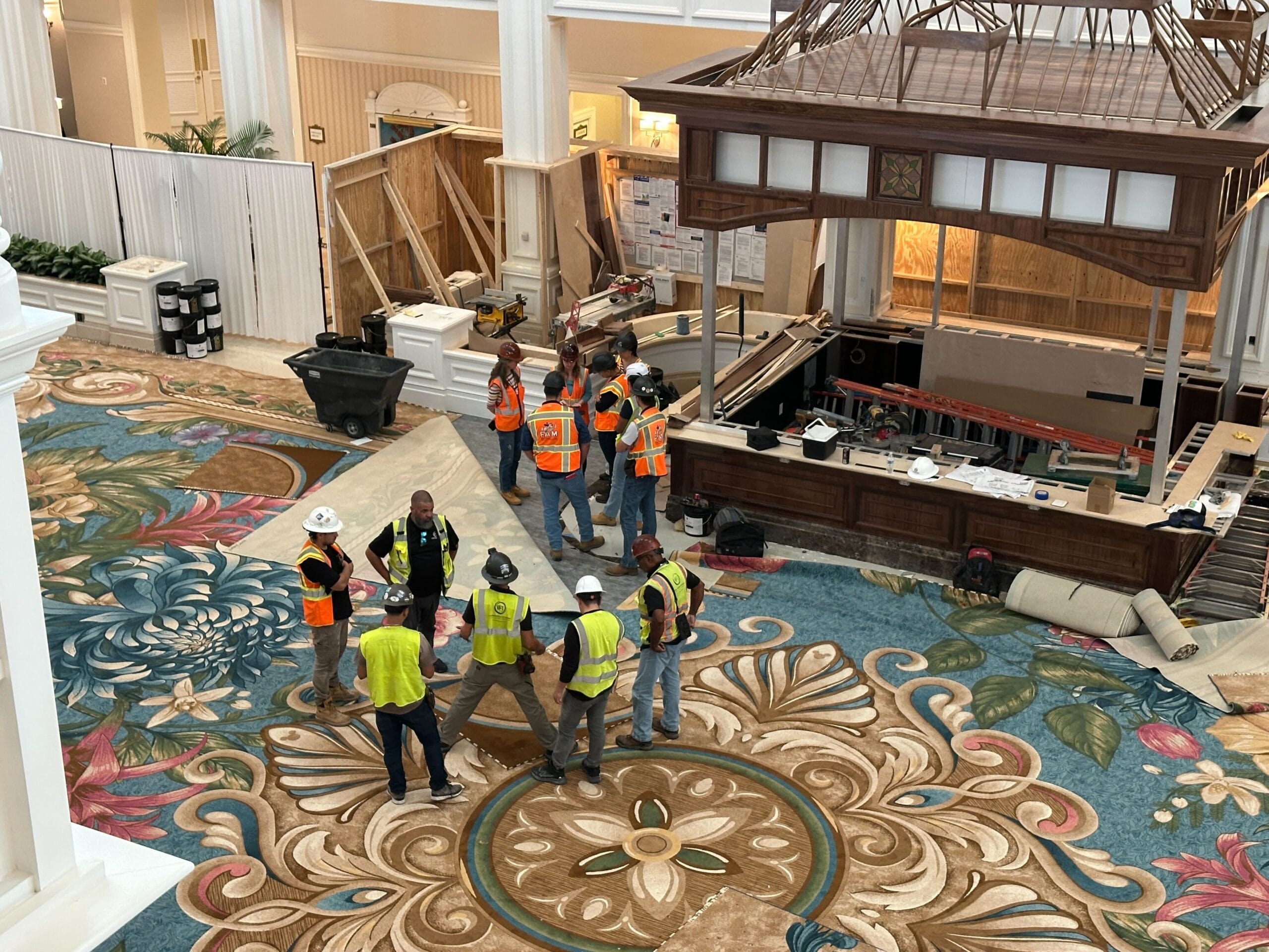 Construction workers in safety vests gather inside the Grand Floridian Lobby as it undergoes renovation at Walt Disney World.