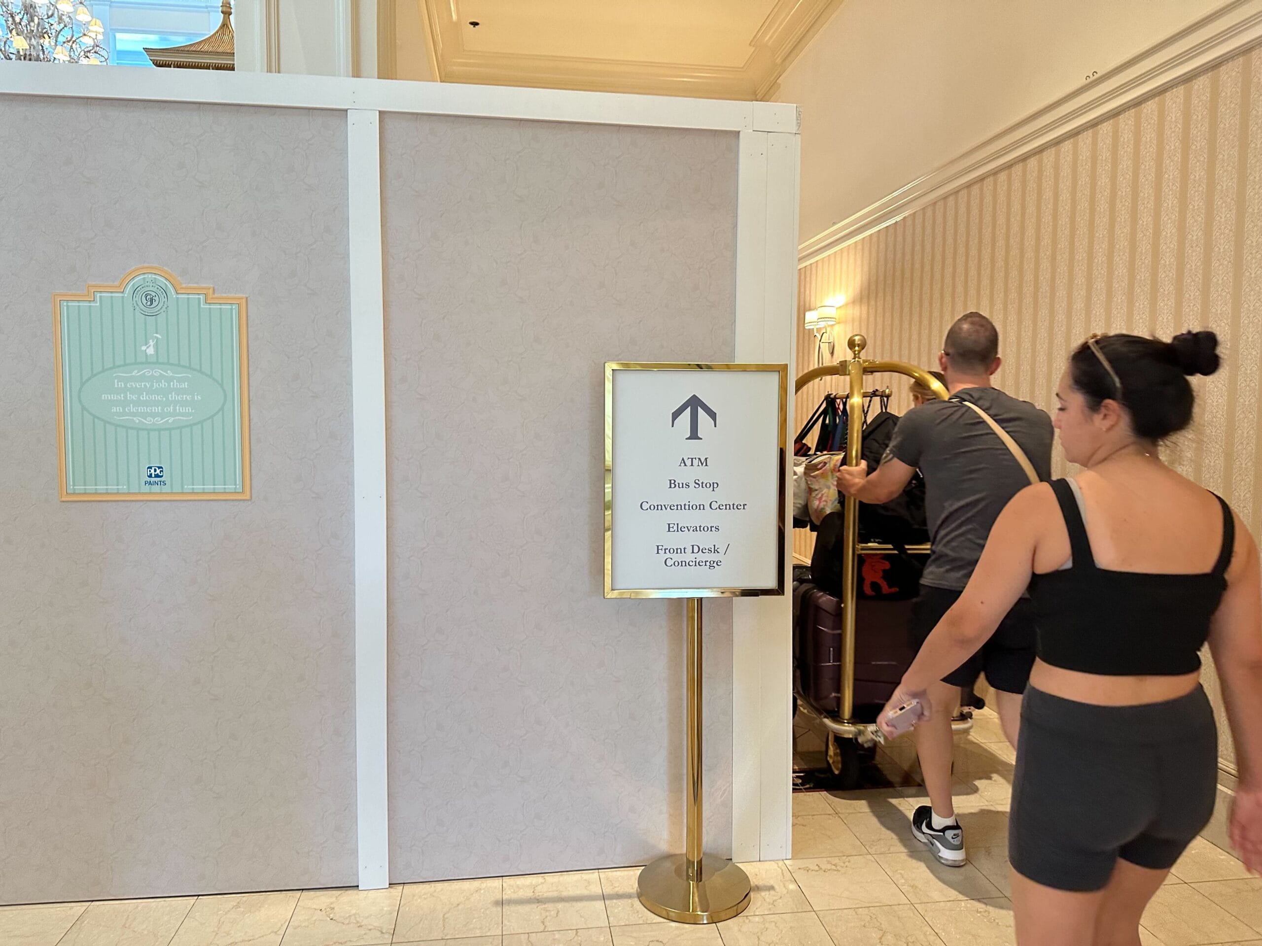 A woman in black workout clothes walks by new signage amid lobby construction at the Grand Floridian hotel.