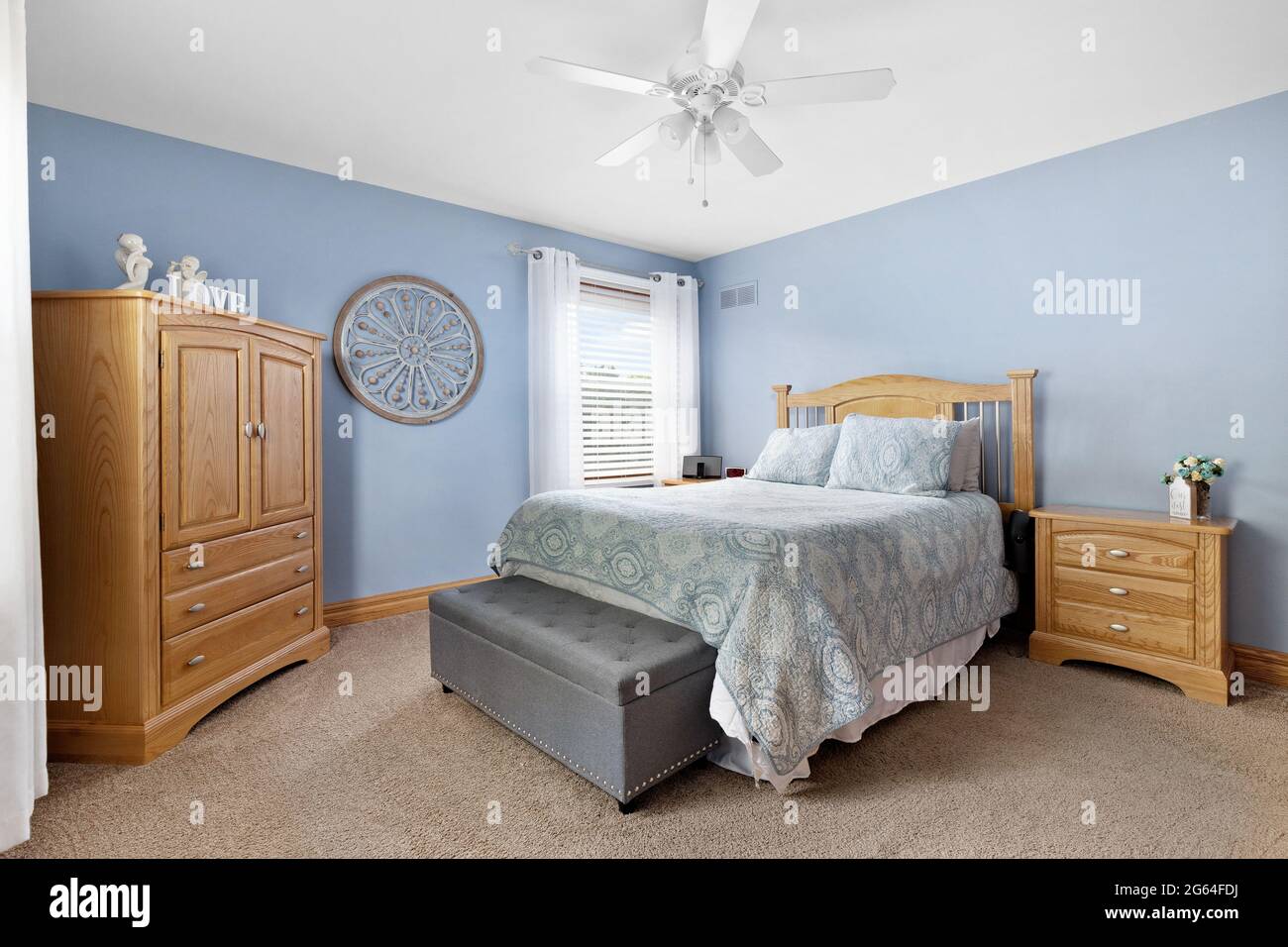 a-cozy-bedroom-with-blue-walls-natural-wood-furniture-and-carpeted-floors-2G64FDJ.jpg