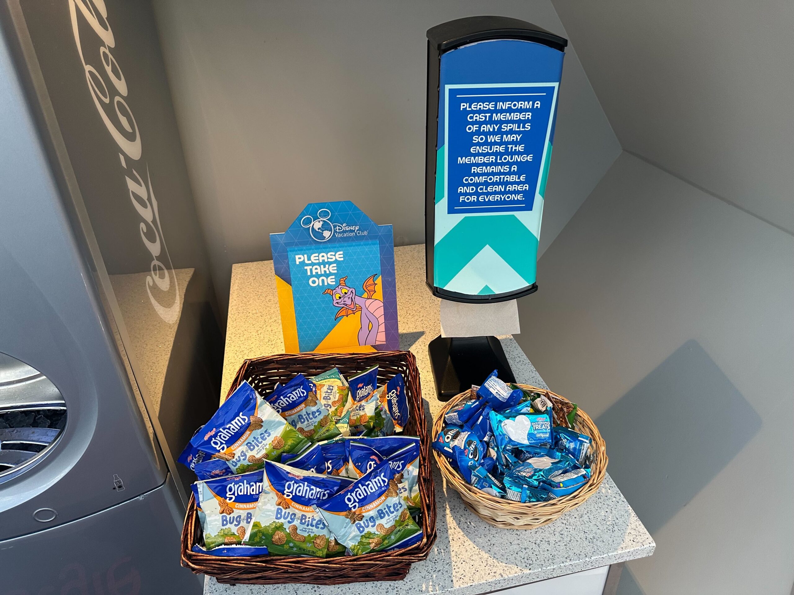 Baskets with Ghirardelli chocolate squares and Bug Bites on a counter. A sign invites people to take one. Baskets with Ghirardelli chocolate squares and Bug Bites on a counter. A sign invites people to take one.