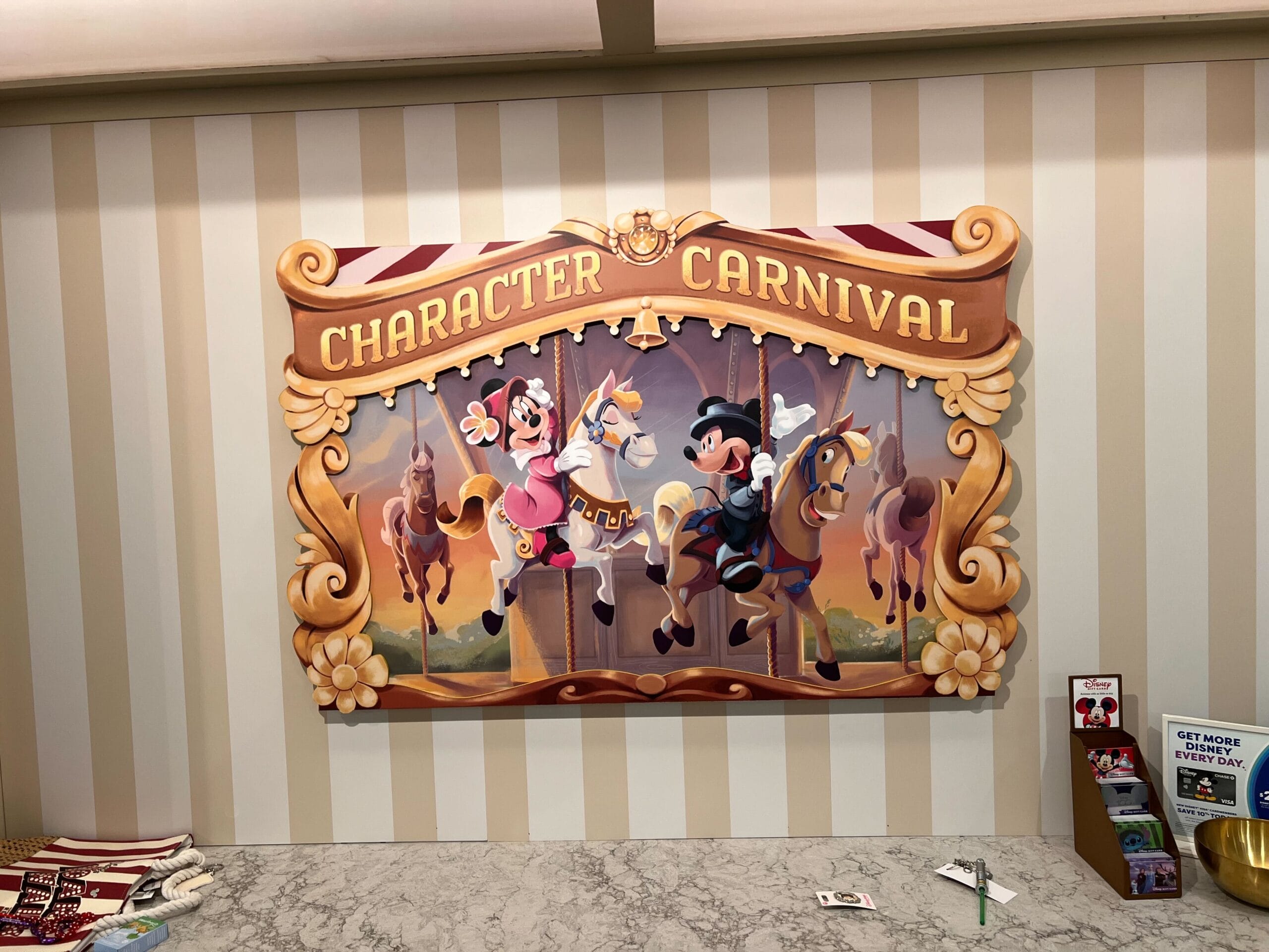 A colorful Character Carnival sign near Thimbles & Threads, with Goofy and Mickey riding carousel horses on stripes. A colorful Character Carnival sign near Thimbles & Threads, with Goofy and Mickey riding carousel horses on stripes.