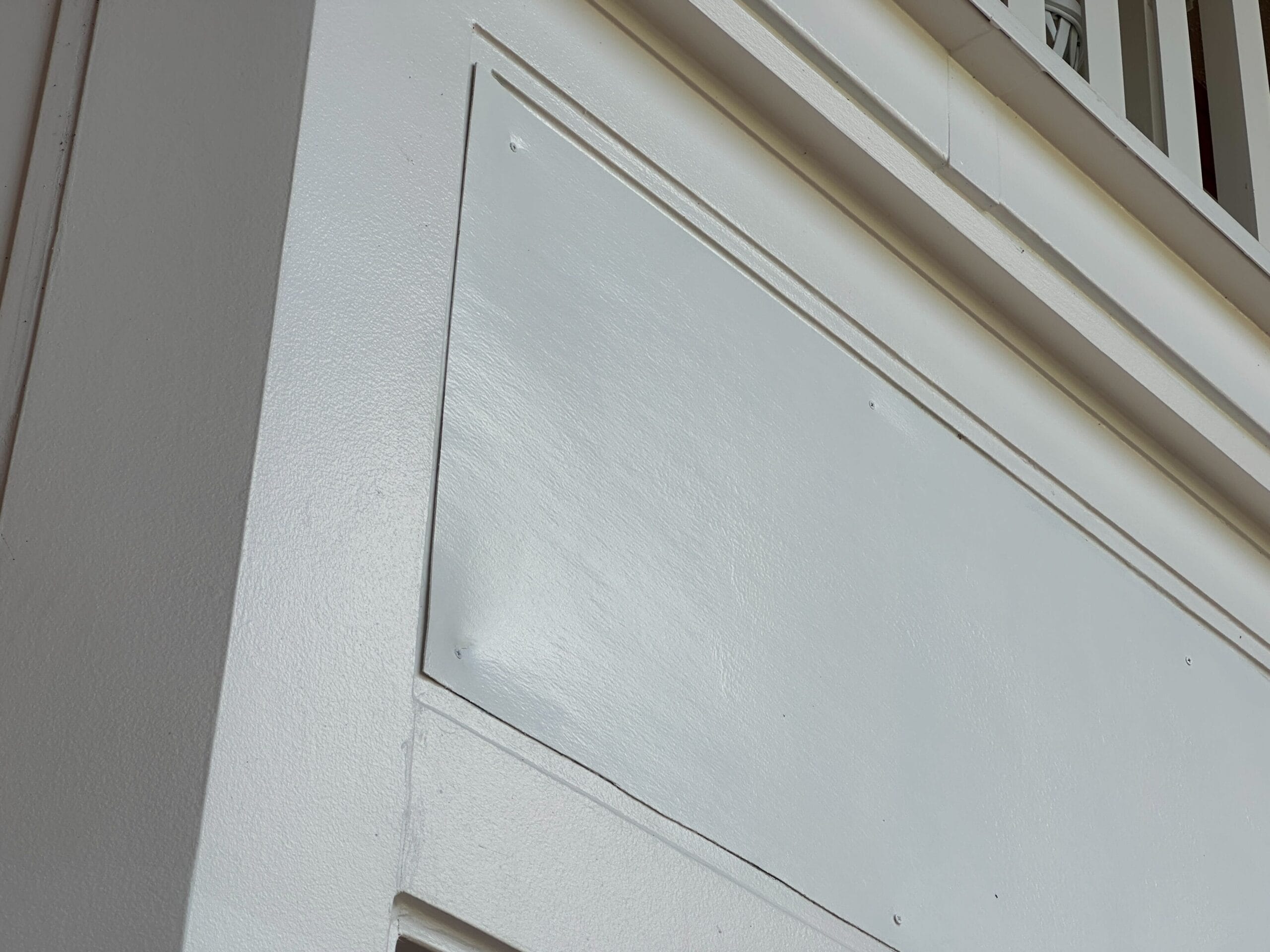 Close-up of a white wall at Disney’s BoardWalk Resort, featuring a rectangular patch cover with corner screws—not a castle view. Close-up of a white wall at Disney’s BoardWalk Resort, featuring a rectangular patch cover with corner screws—not a castle view.