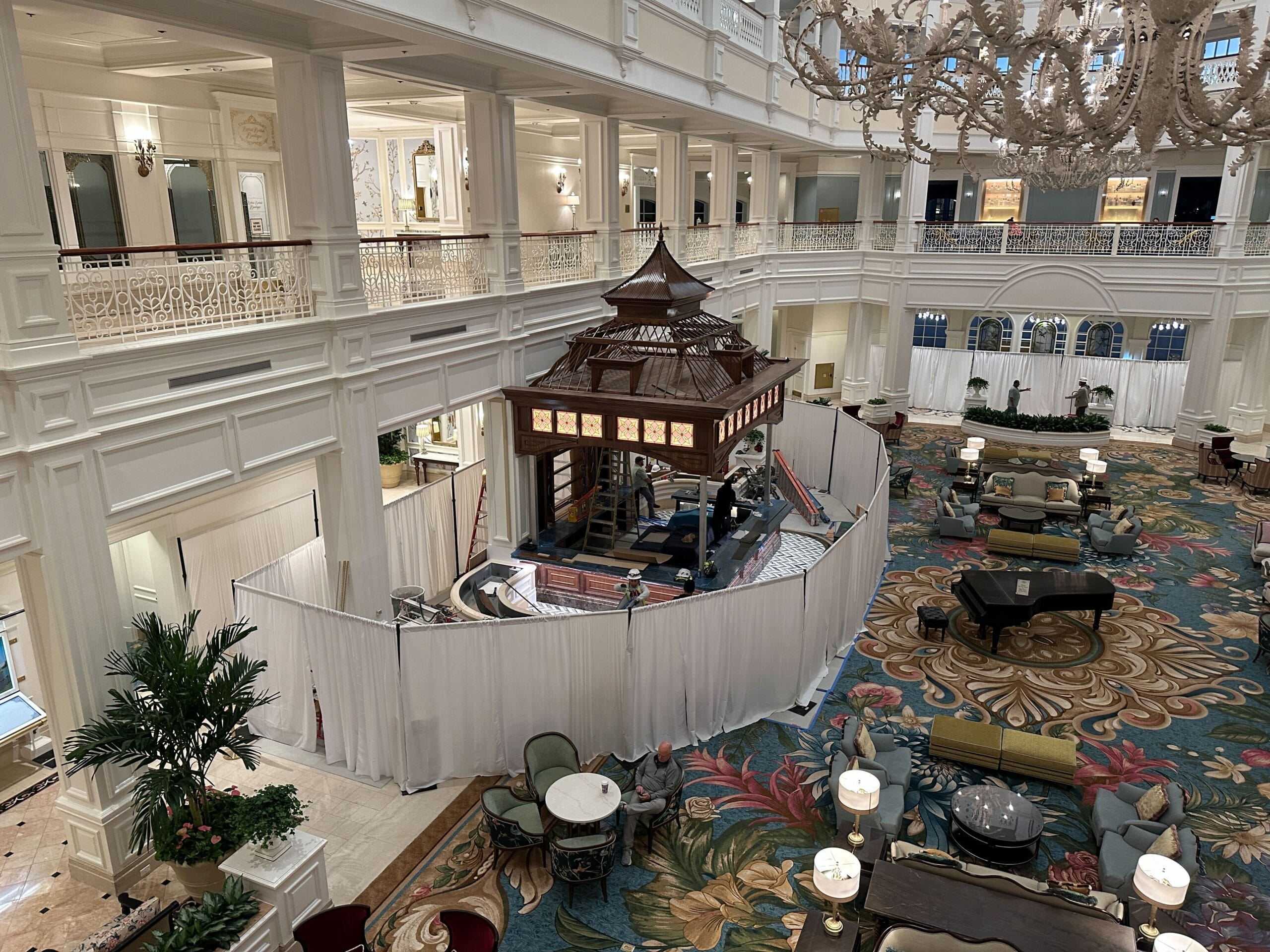 Grand Floridian hotel lobby, bright and elegant; center floor hidden behind white curtains and wooden framing for construction. Grand Floridian hotel lobby, bright and elegant; center floor hidden behind white curtains and wooden framing for construction.