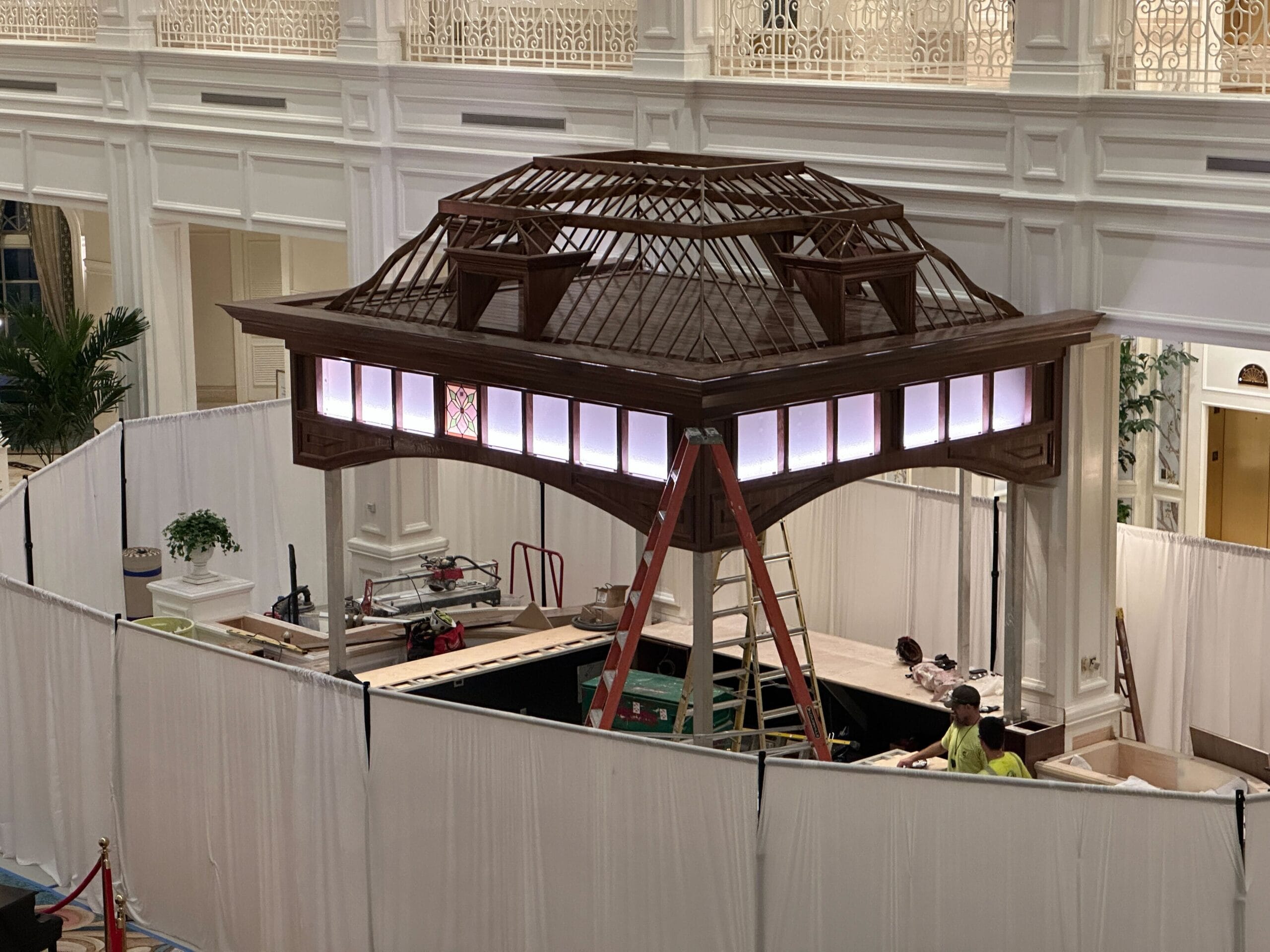 A wooden gazebo with white curtains is being built during lobby renovations at Disney’s Grand Floridian, evoking classic resort elegance. A wooden gazebo with white curtains is being built during lobby renovations at Disney’s Grand Floridian, evoking classic resort elegance.