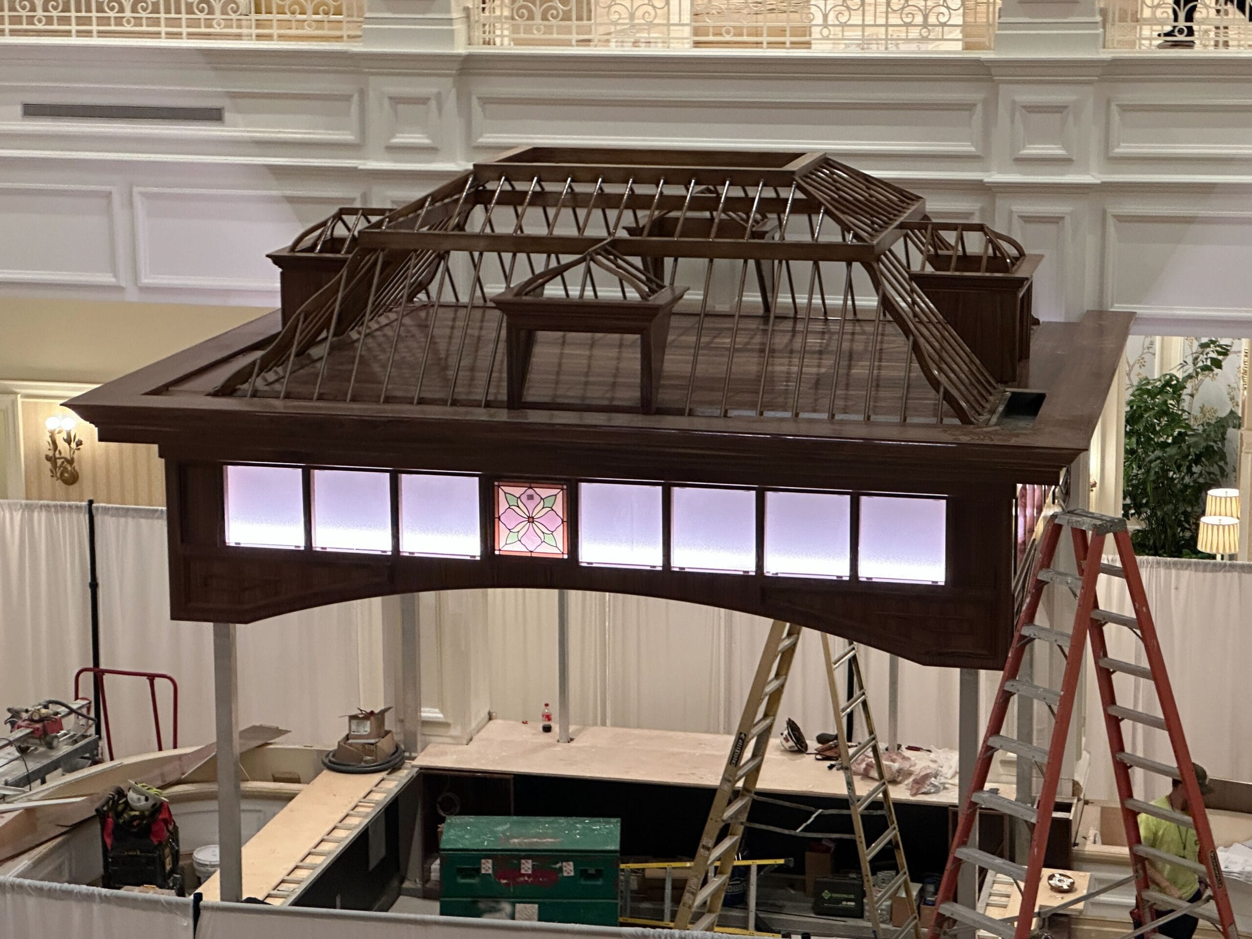 A large, partially built wooden structure with ladders and tools hints at a Disney hotel lobby refurbishment and updated lighting. A large, partially built wooden structure with ladders and tools hints at a Disney hotel lobby refurbishment and updated lighting.