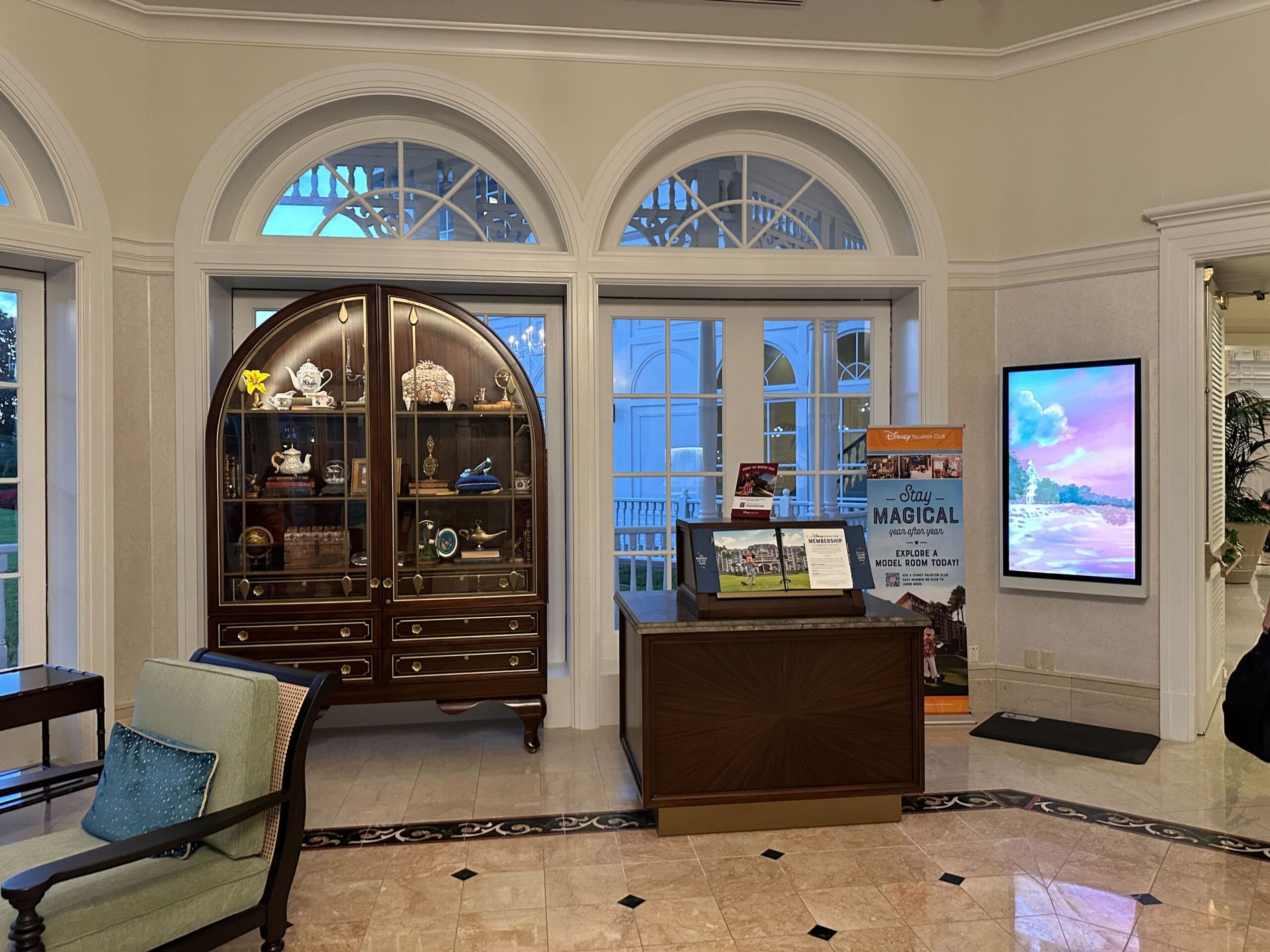 View of the refurbished Grand Floridian lobby with a wooden display case featuring Disney themed collectibles next to a Disney Vacation Club information kiosk. View of the refurbished Grand Floridian lobby with a wooden display case featuring Disney themed collectibles next to a Disney Vacation Club information kiosk.