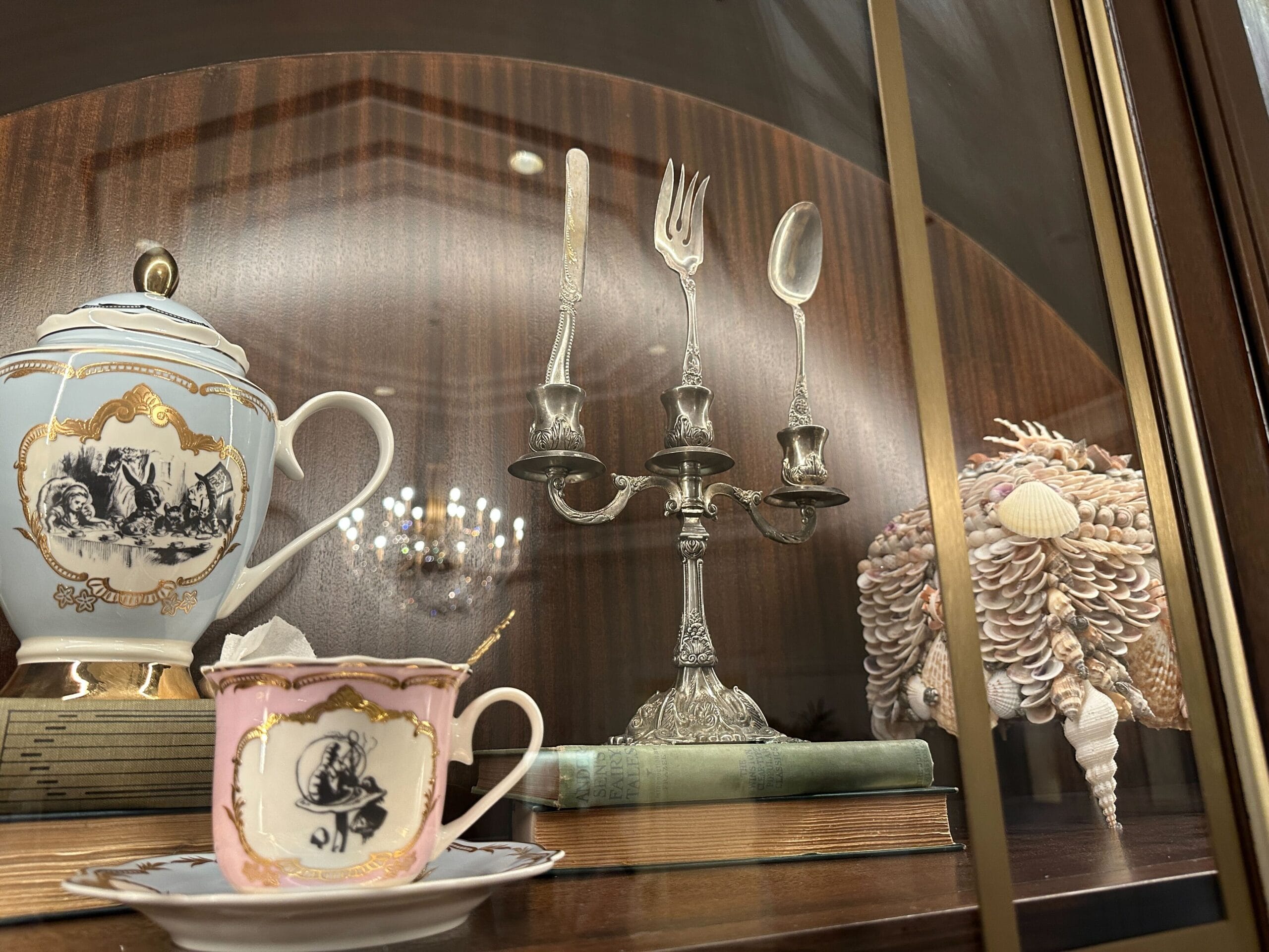 A silver candelabra with cutlery in place of candles sits on a shelf in a glass-front display case in the refurbished Grand Floridian lobby bar. A silver candelabra with cutlery in place of candles sits on a shelf in a glass-front display case in the refurbished Grand Floridian lobby bar.