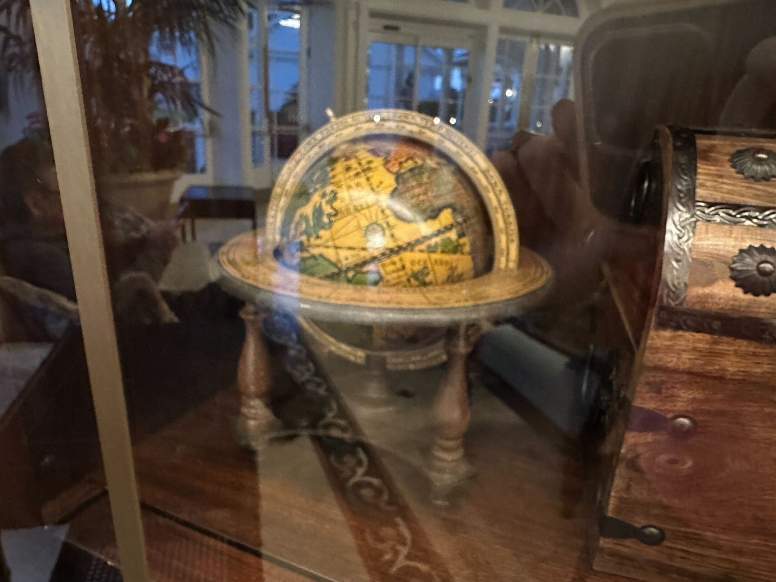 A small, vintage globe on a wooden stand in a glass-front display case in the refurbished Grand Floridian lobby bar. A small, vintage globe on a wooden stand in a glass-front display case in the refurbished Grand Floridian lobby bar.