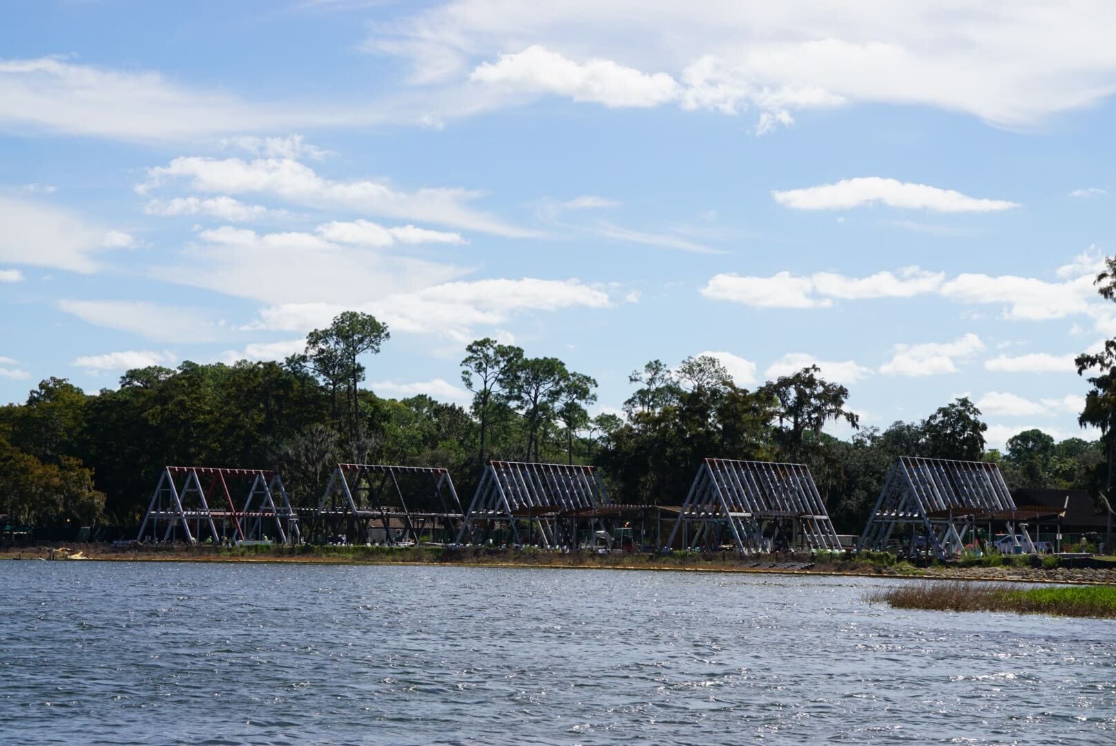 Triangular metal structures line the lakeshore, reminiscent of EPCOT’s geometric architecture in a scenic Lakeshore Update. Triangular metal structures line the lakeshore, reminiscent of EPCOT’s geometric architecture in a scenic Lakeshore Update.