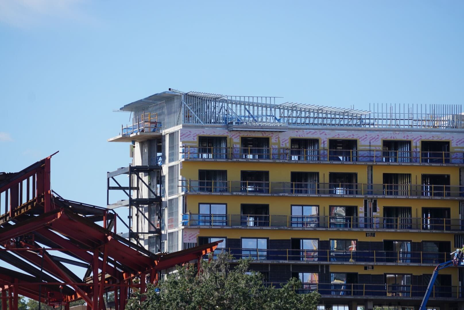 Lakeshore Update: A multi-story building with yellow walls and exposed metal framework rises, reminiscent of Disney resort construction. Lakeshore Update: A multi-story building with yellow walls and exposed metal framework rises, reminiscent of Disney resort construction.