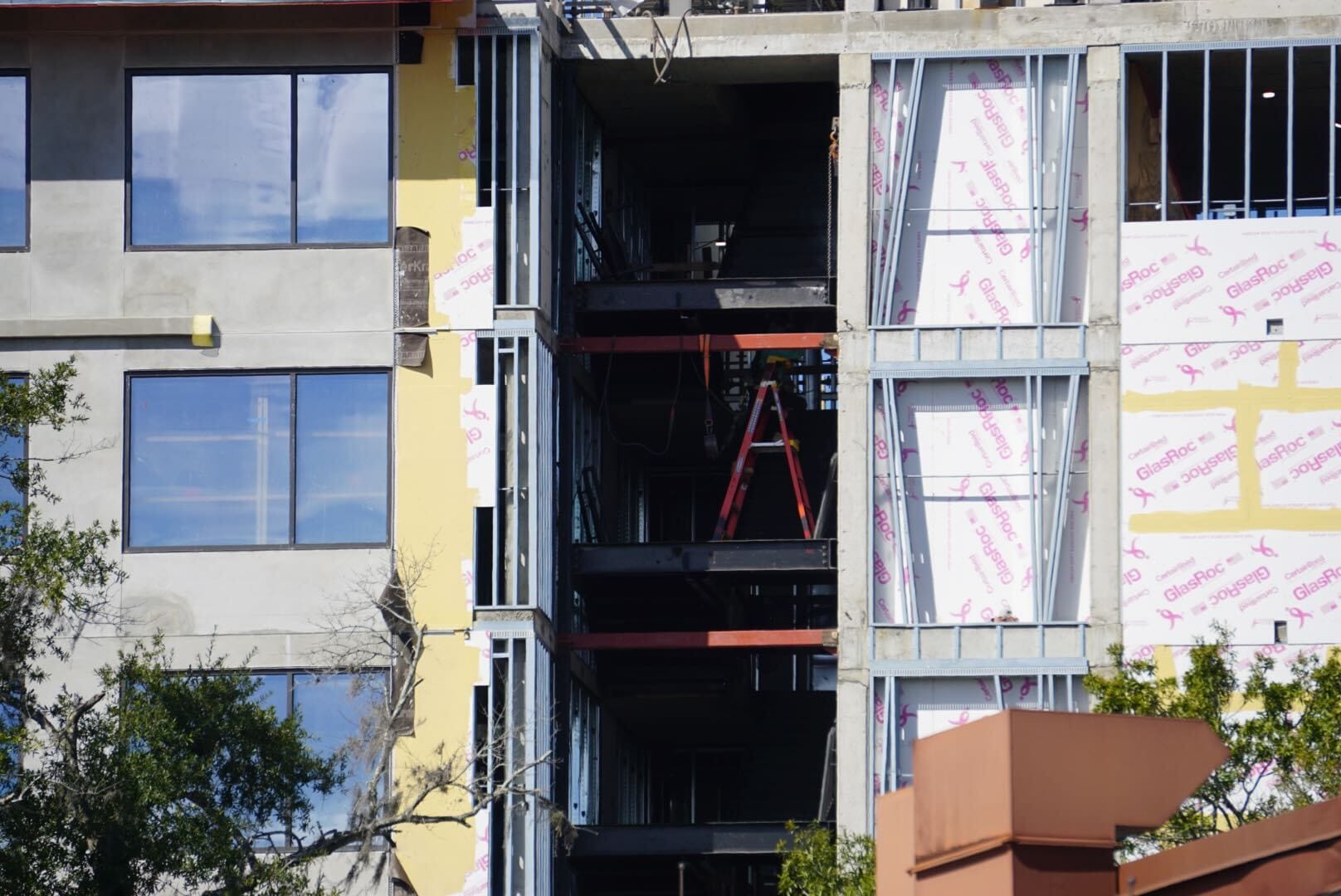 Lakeshore Update: Building under construction with visible insulation, red ladder, and finished windows—no Disney castle elements present. Lakeshore Update: Building under construction with visible insulation, red ladder, and finished windows—no Disney castle elements present.